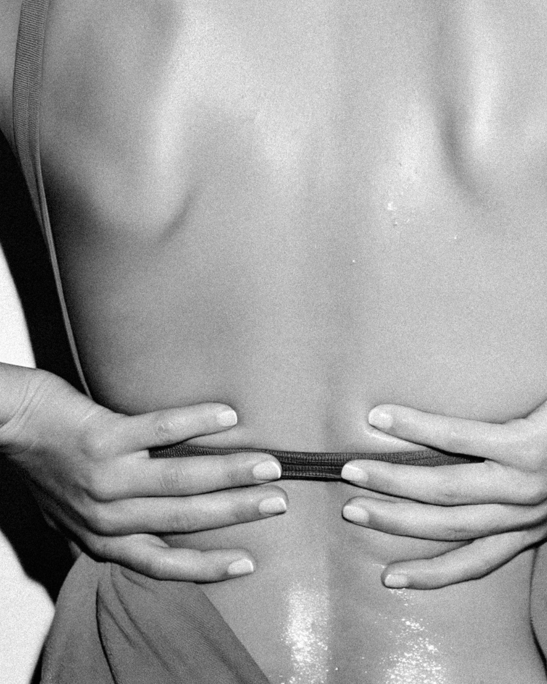 Close-up of a person's bare torso, hands holding the waistband of their underwear.