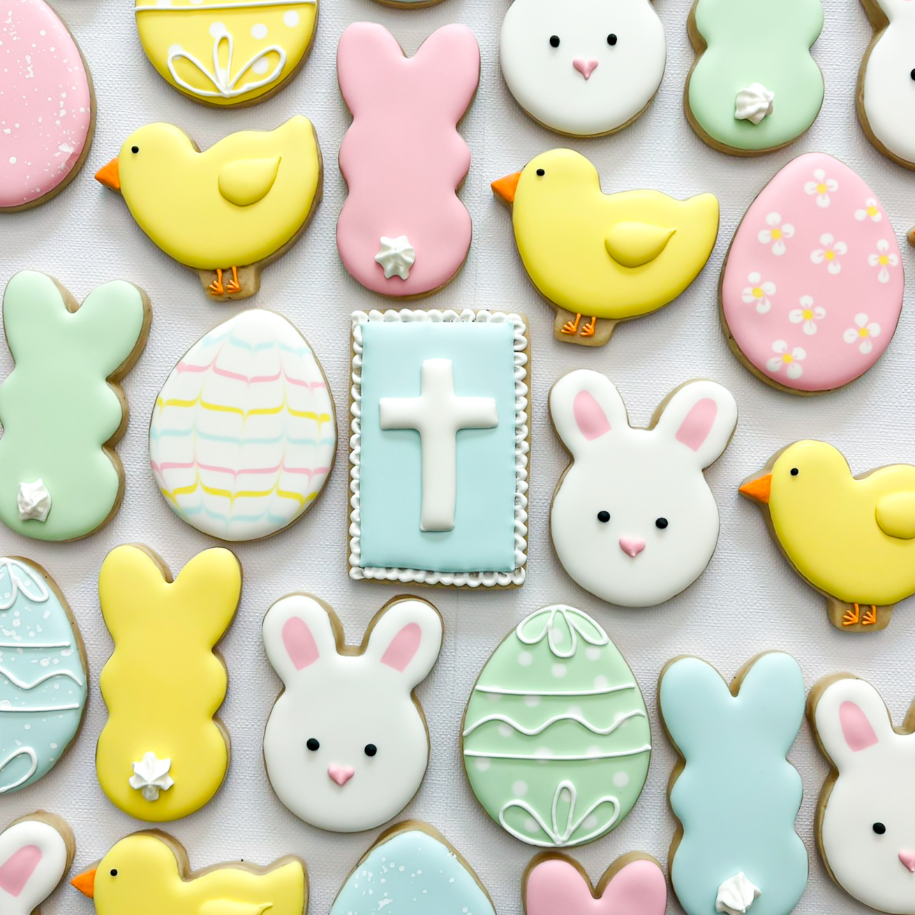 Decorative Easter cookies with bunny, chick, egg, cross, and heart shapes in pastel colors.