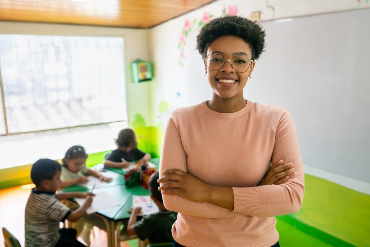Smiling women teacher in a colorful classroom