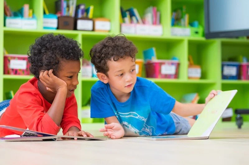 Two boys reading books together
