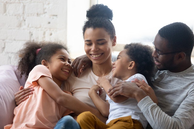 Happy family with children hugging mom
