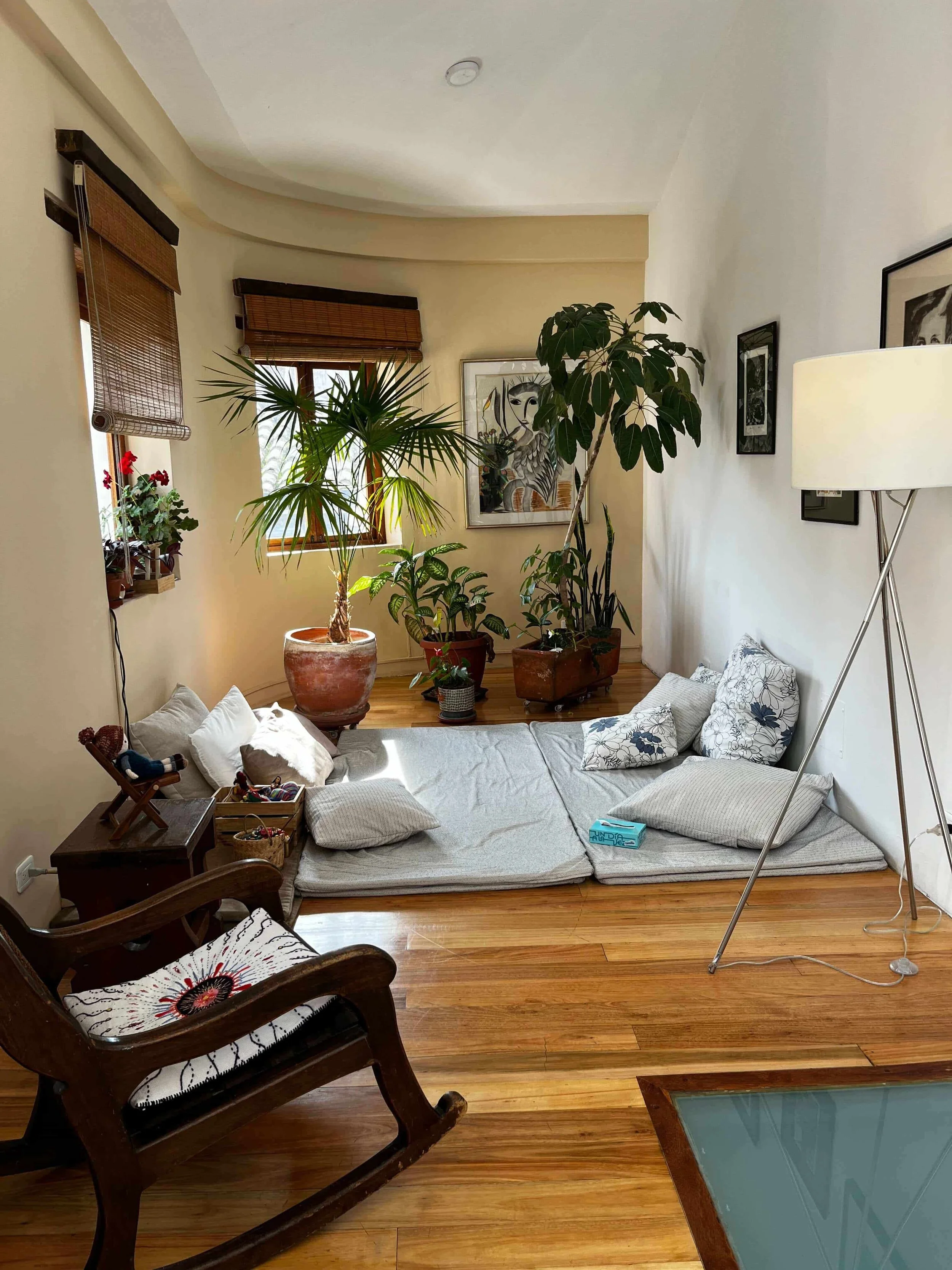 Consultorio de terapia de Verónica Ávila en Quito; un espacio cálido con luz natural, plantas y cojines en el suelo, diseñado para facilitar la relajación y el trabajo terapéutico profundo.