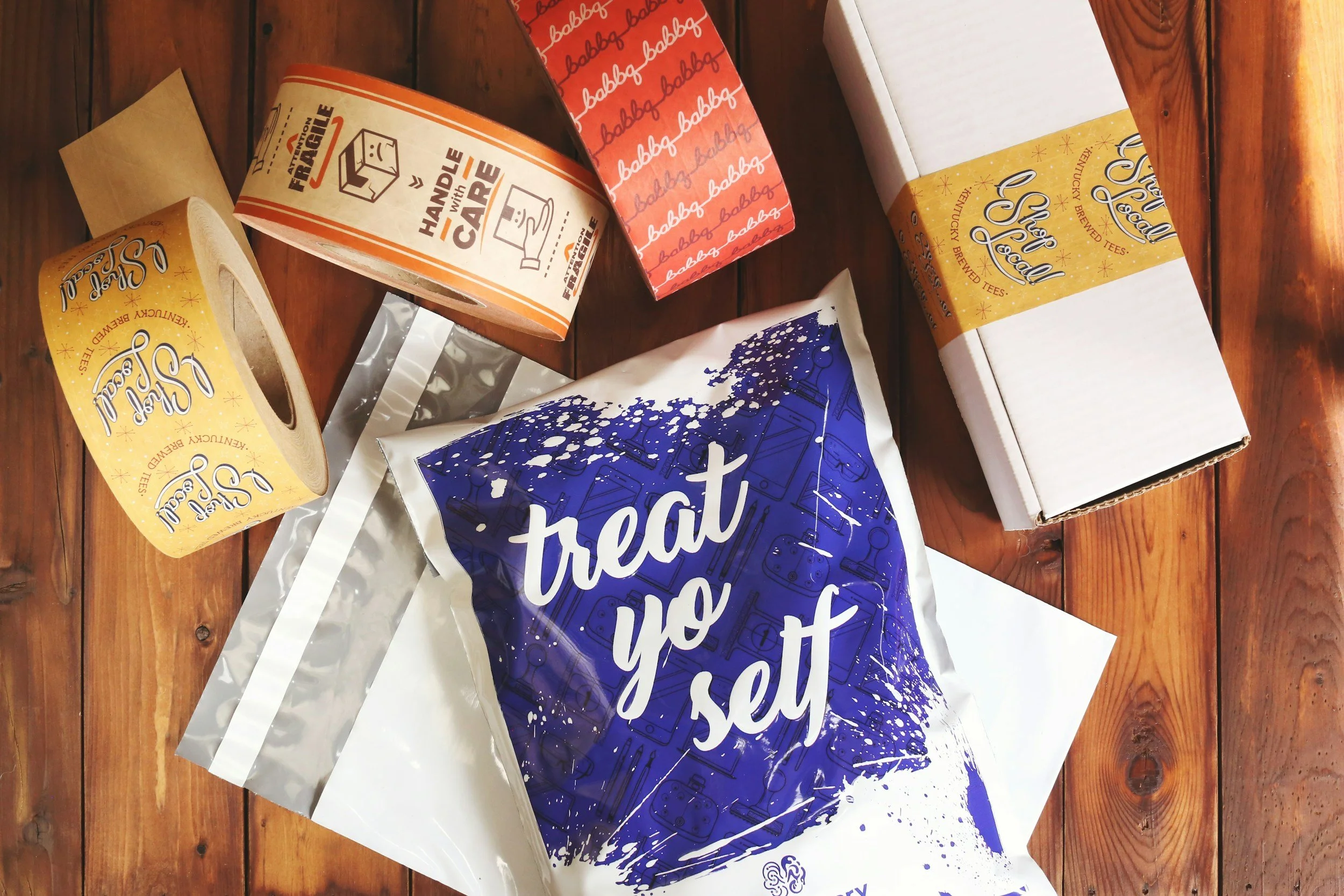 Variedad de empaques de té y productos de papel con el mensaje 'treat yo set' en una mesa de madera