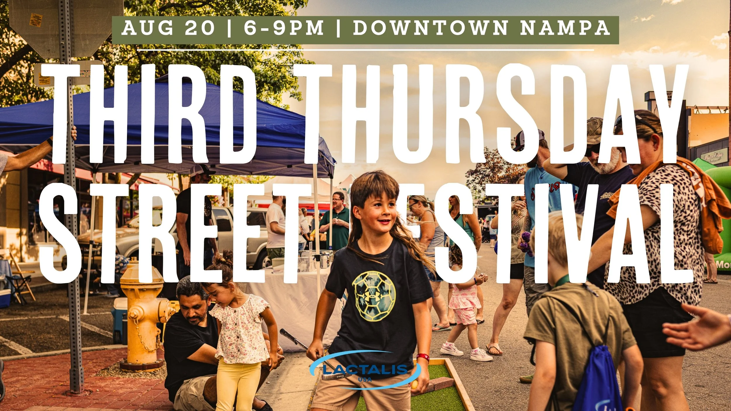 This photo shows people grouped around a mini-putting green staged at a Third Thursday Street Market. In the center, is an elementary school age boy with a golf putter.