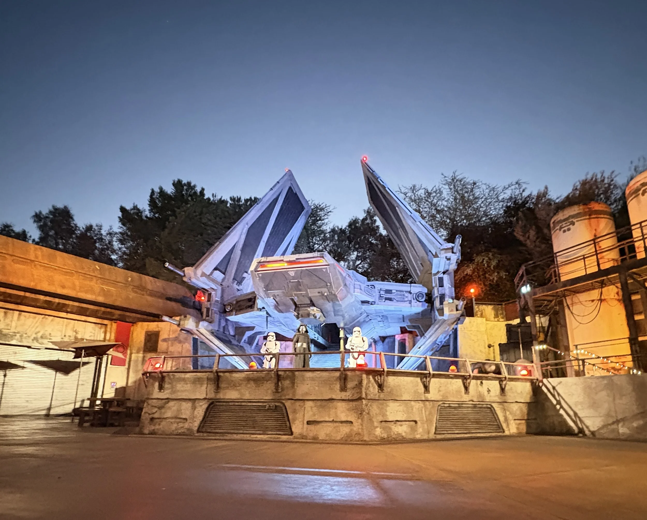 Star Wars: Galaxy's Edge Millennium Falcon ride at night with two stormtroopers standing in front, illuminated by artificial lighting.