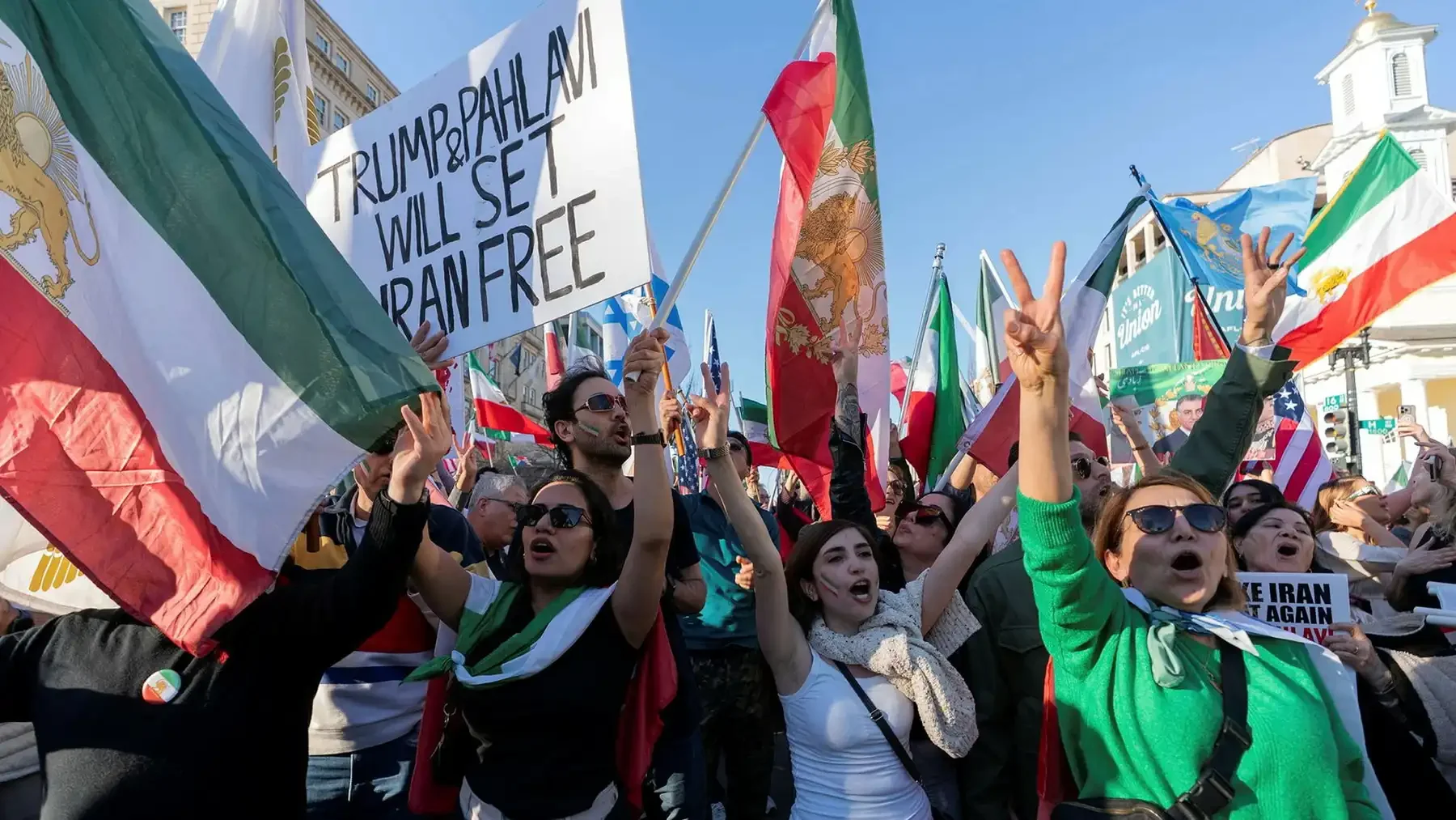 Man med mörkt, lockigt hår, bär ringar och armband, håller händerna nära huvudet, visar smycken.
