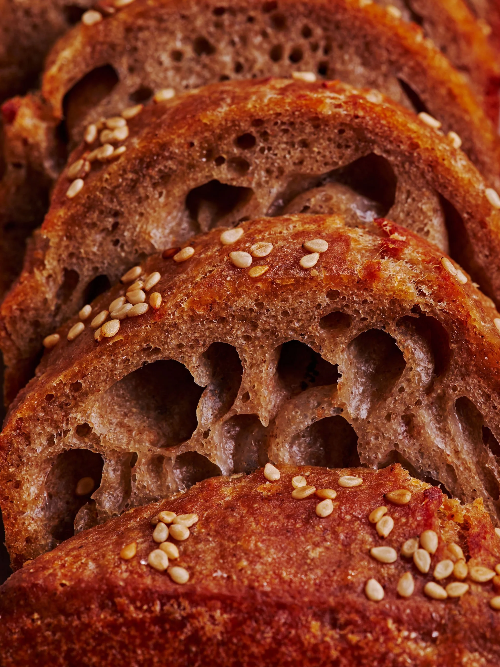Close-up of toasted slices of bread topped with sesame seeds.