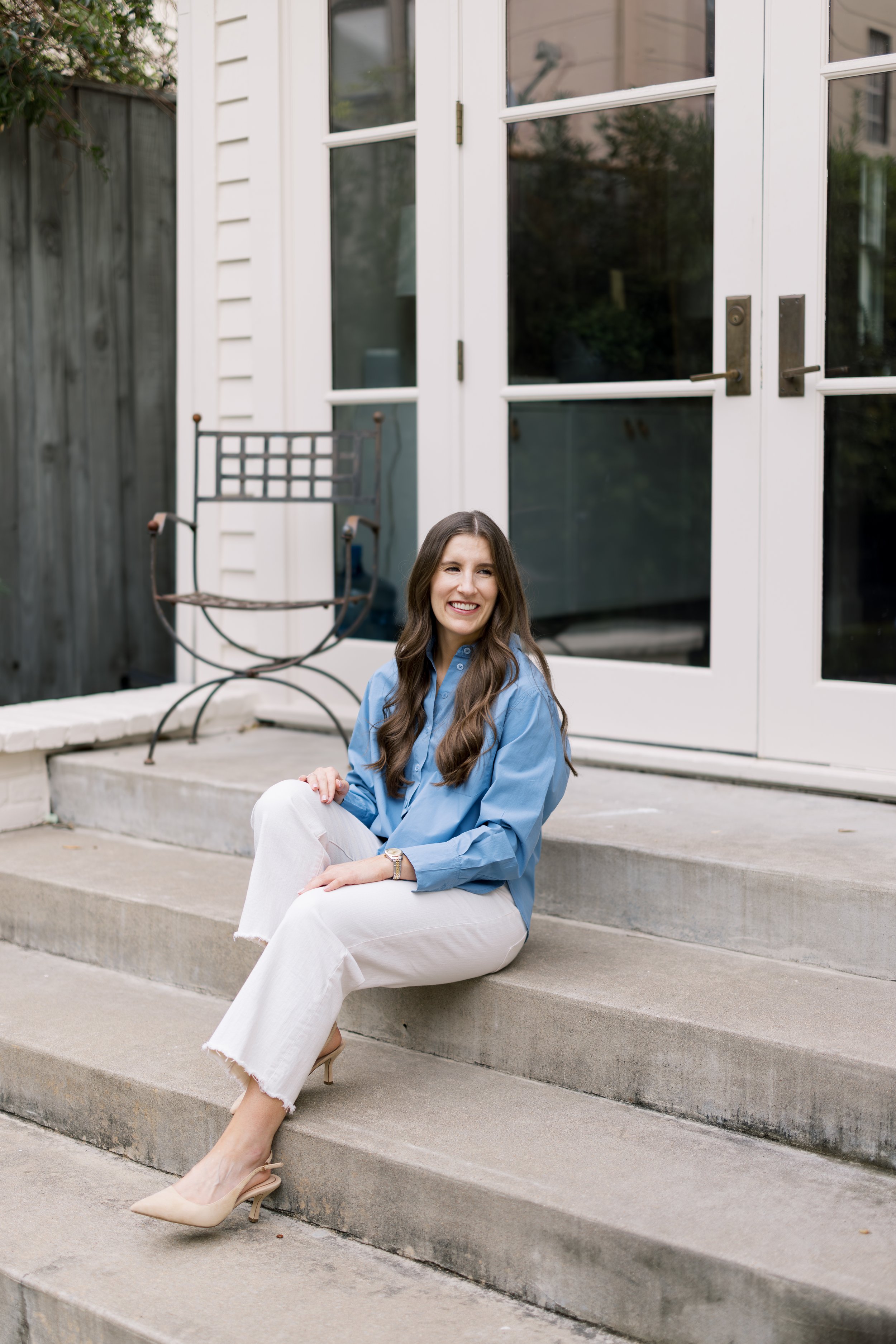 Lydia Johnson sitting on steps, looking off to the side and smiling.