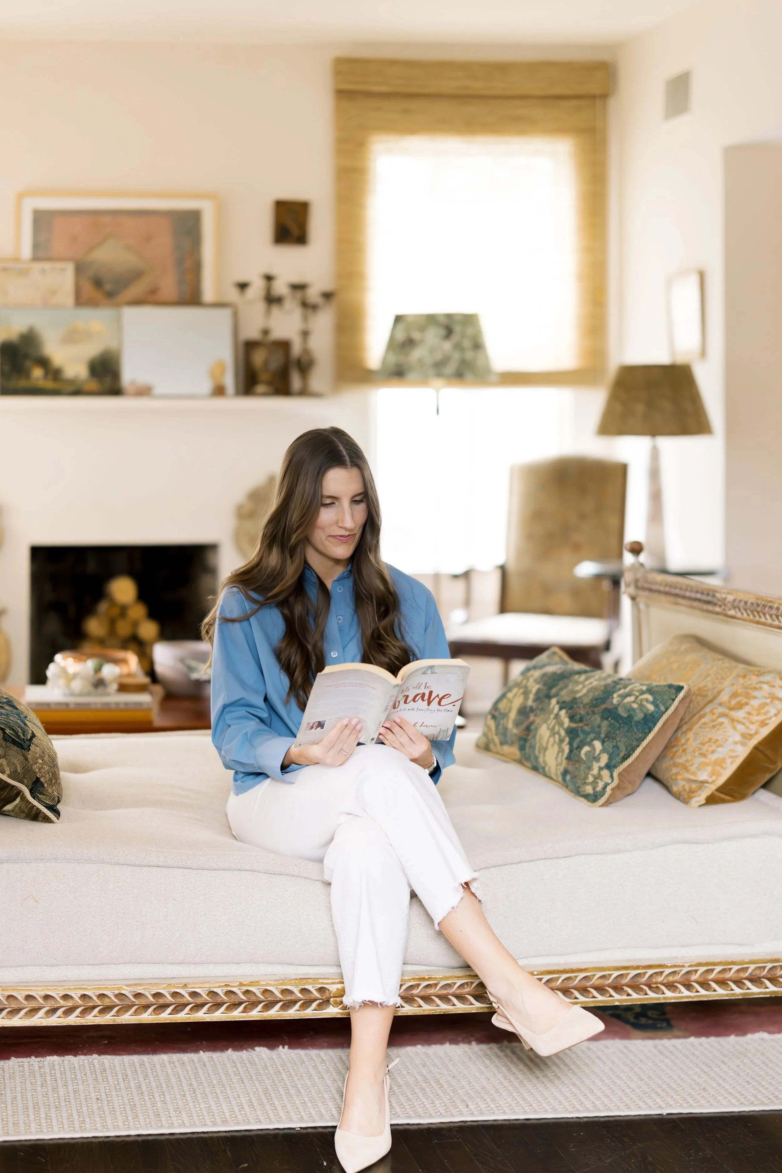 Lydia Johnson sitting on chaise reading a book