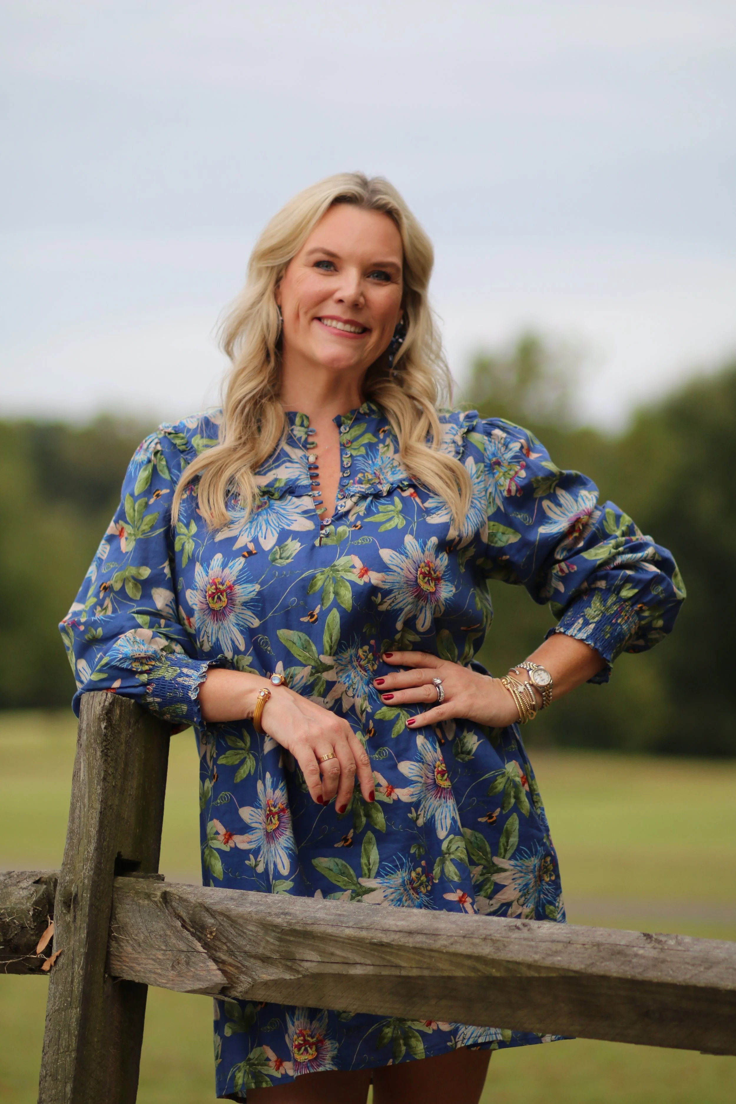 Stephanie of Visceral by Design, interior designer based in High Point North Carolina, standing outdoors in blue floral dress