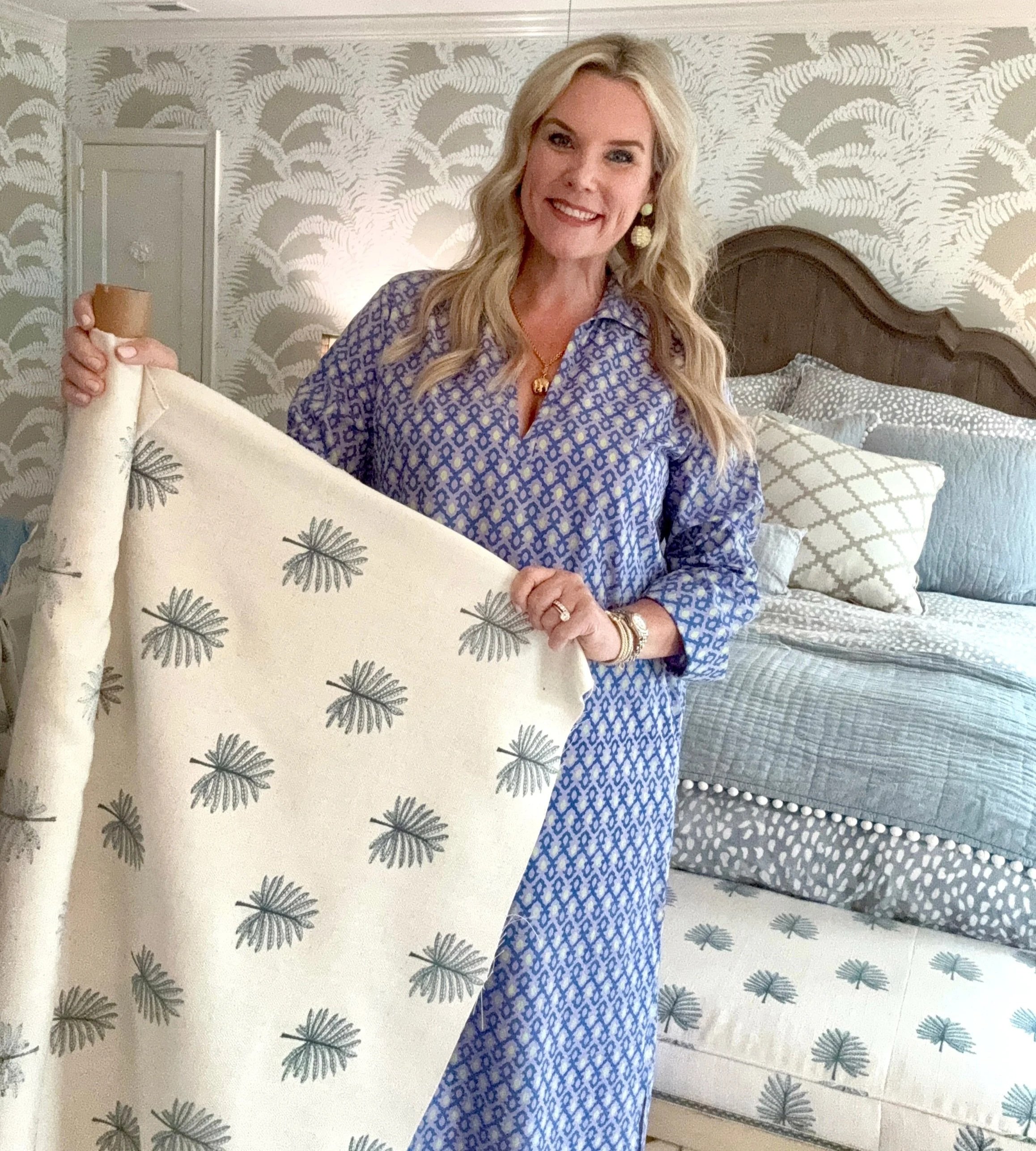 Stephanie of Visceral by Design selecting patterned fabric in a styled bedroom, showcasing interior design work in High Point NC