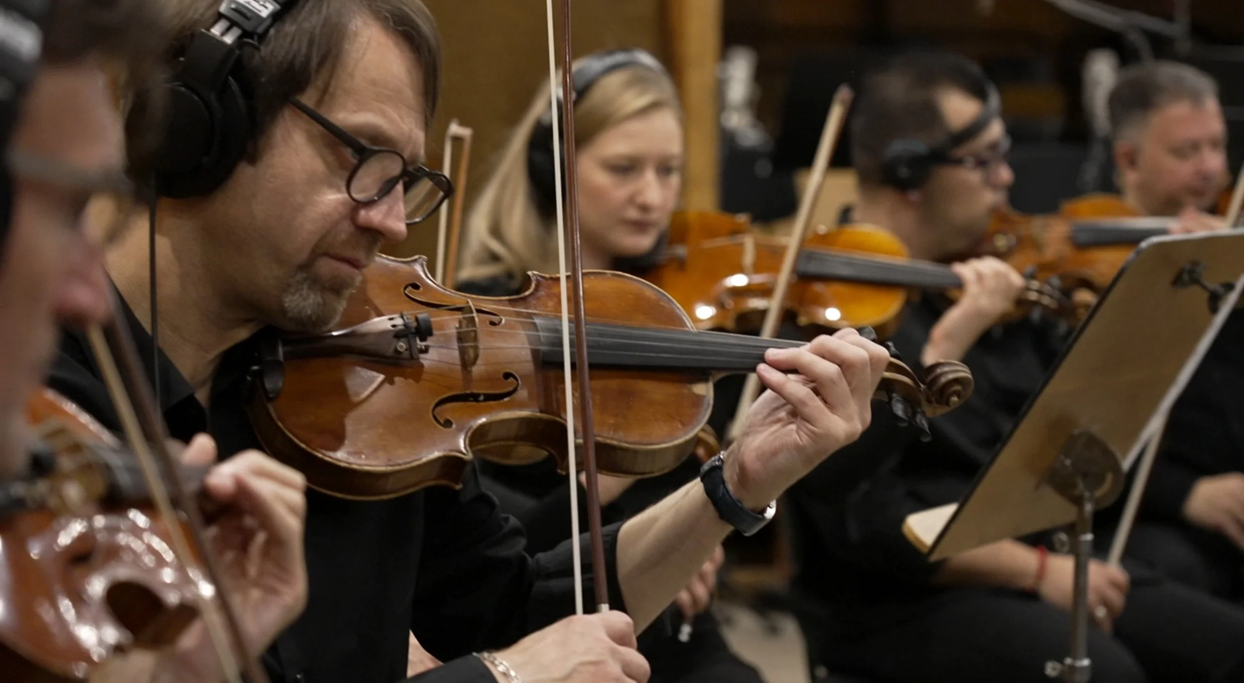 오케스트라 연주자가 바이올린을 연주하는 모습.