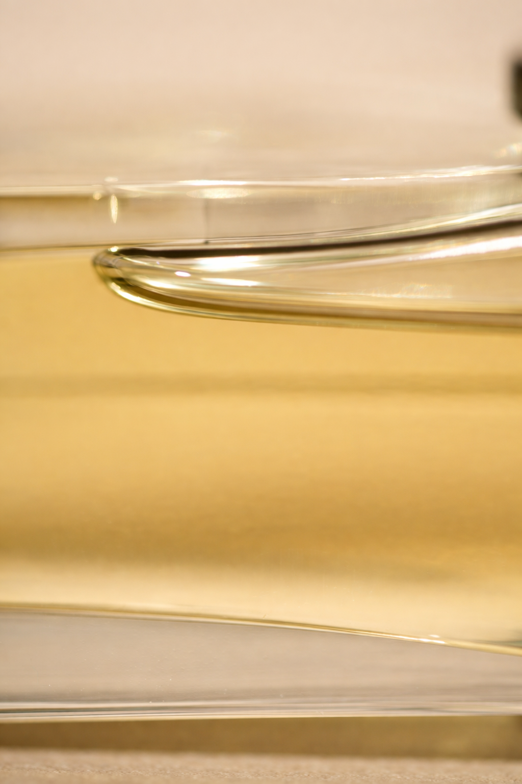 Close-up of a glass container or lid with metallic edges, placed on a wooden surface.