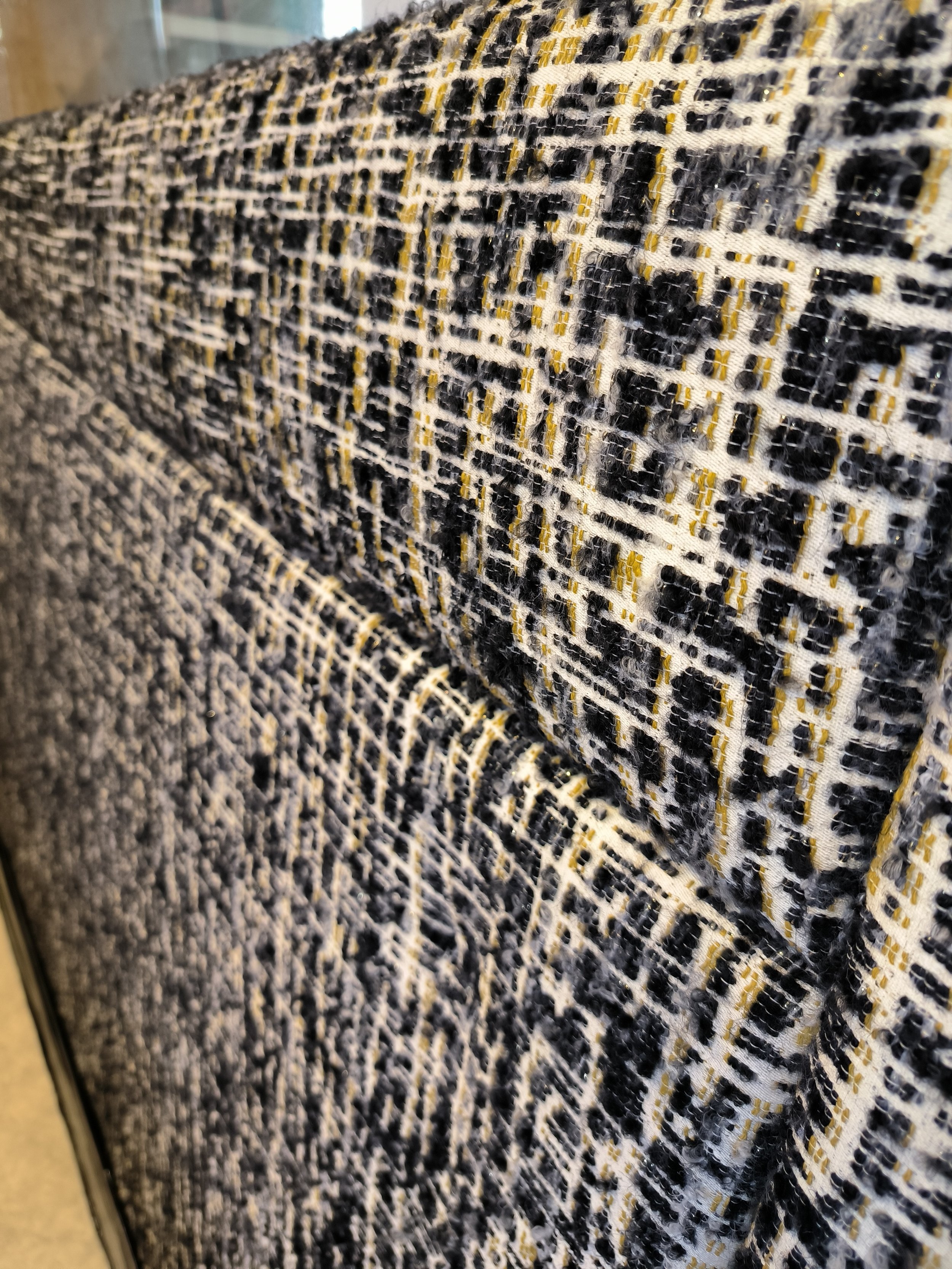 Tissu tissé avec un motif, des lignes blanches, noir, avec des éléments dorés.