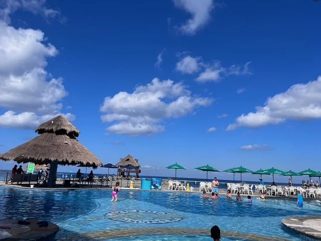 Boutique beach resort pool with cabanas and lounge chairs