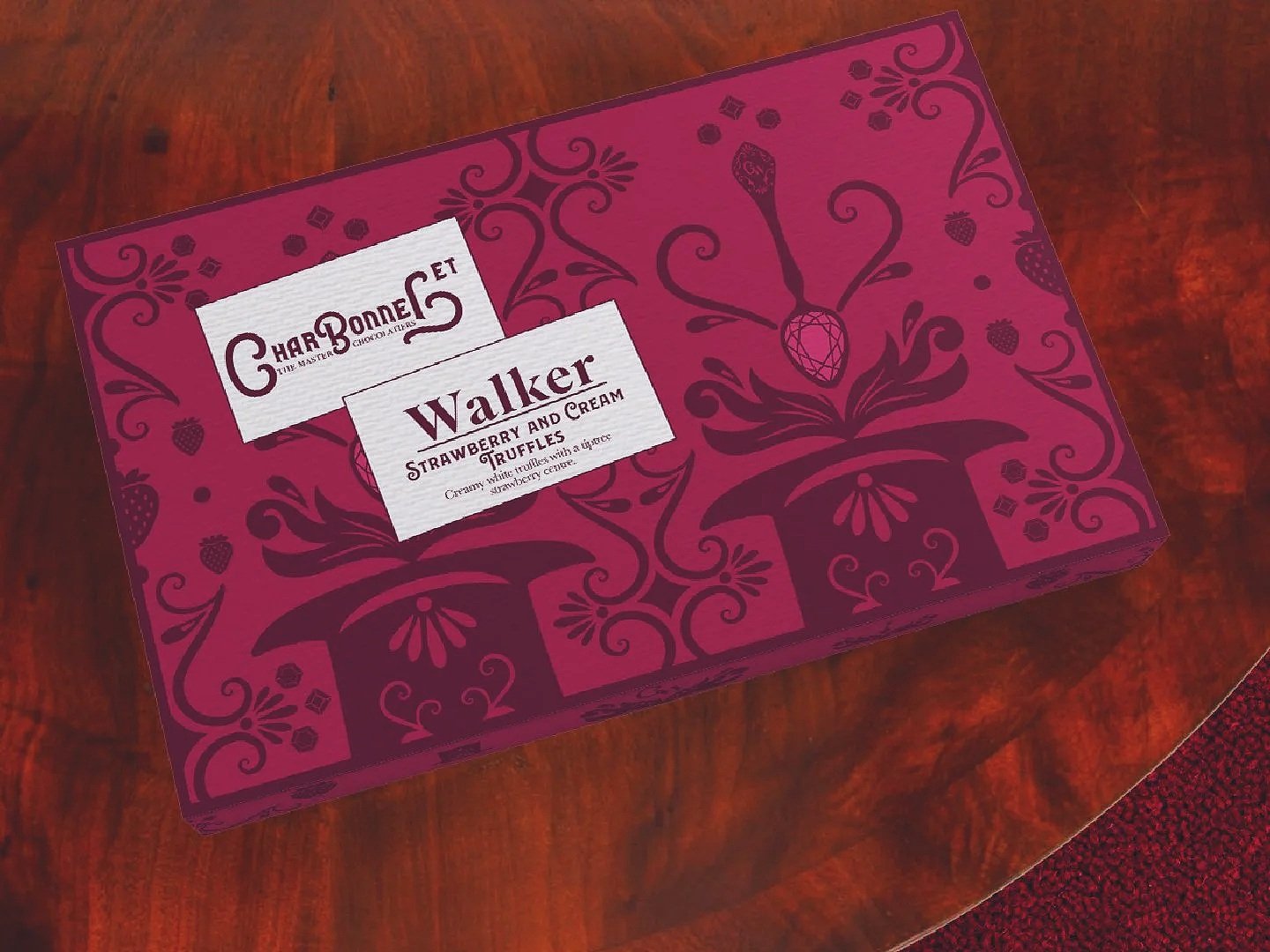 A rectangular box of Charbonneet Walker strawberry and cream truffles on a wooden surface