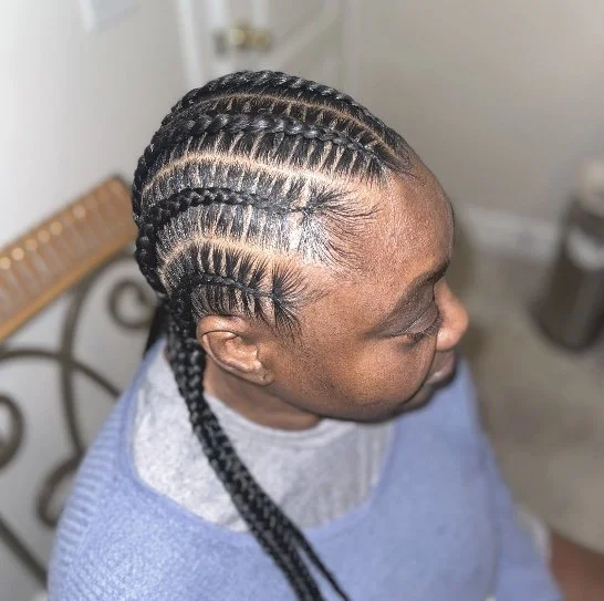Close-up of a woman with freshly braided cornrows on the side of her head.
