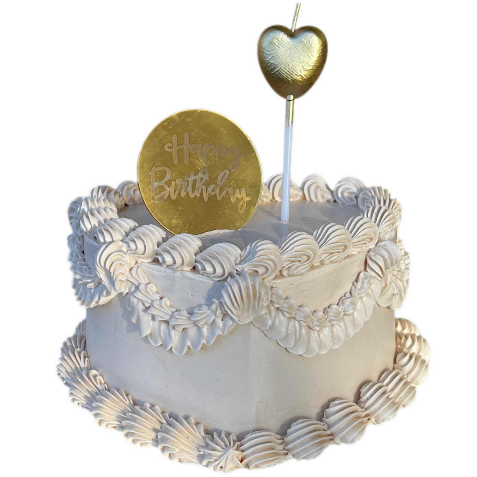 A white birthday cake decorated with piped white frosting and gold accents, topped with a gold heart-shaped decoration and a circular gold 'Happy Birthday' topper.
