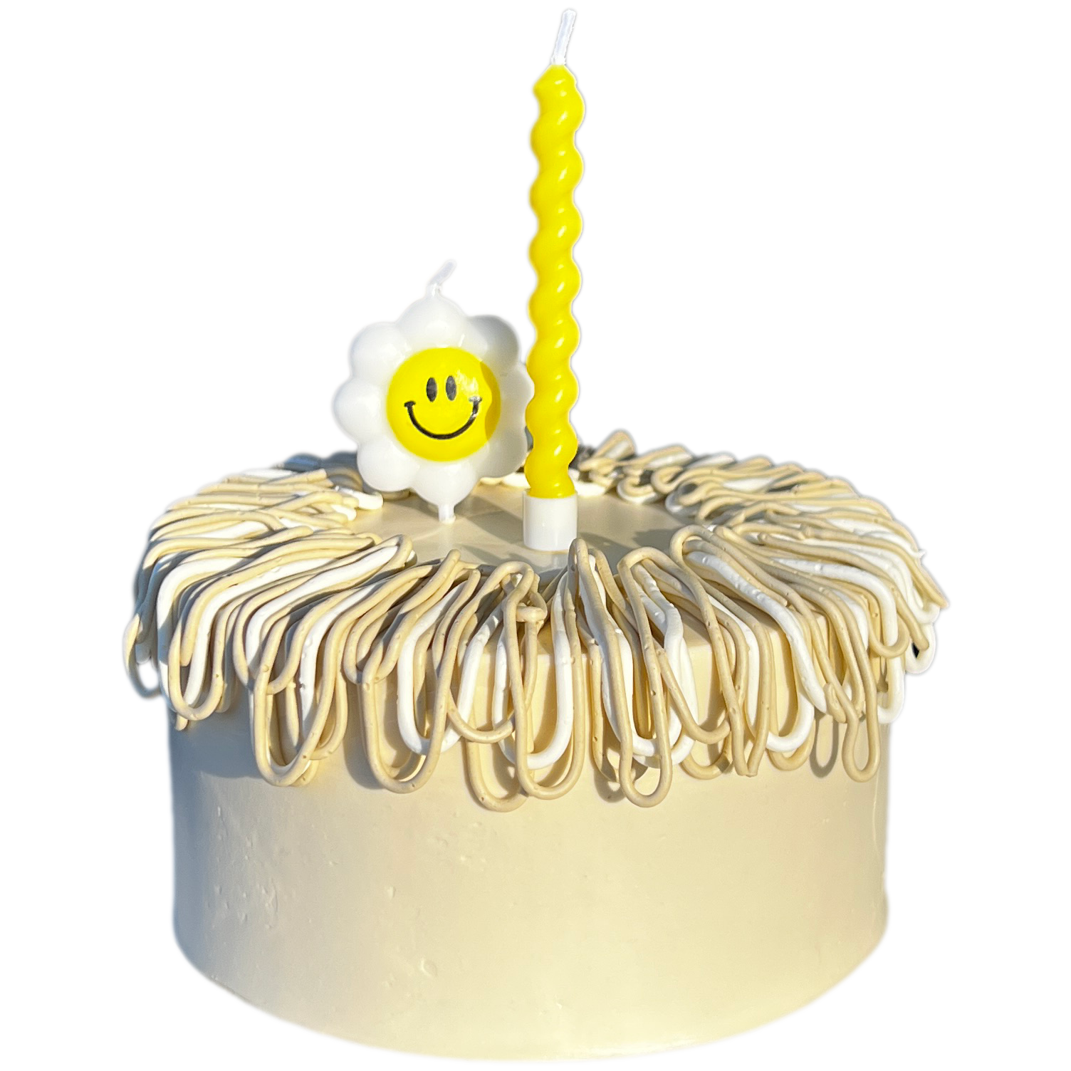 A white birthday cake decorated with white and yellow icing, topped with a smiling flower-shaped candle and a tall yellow spiral candle.