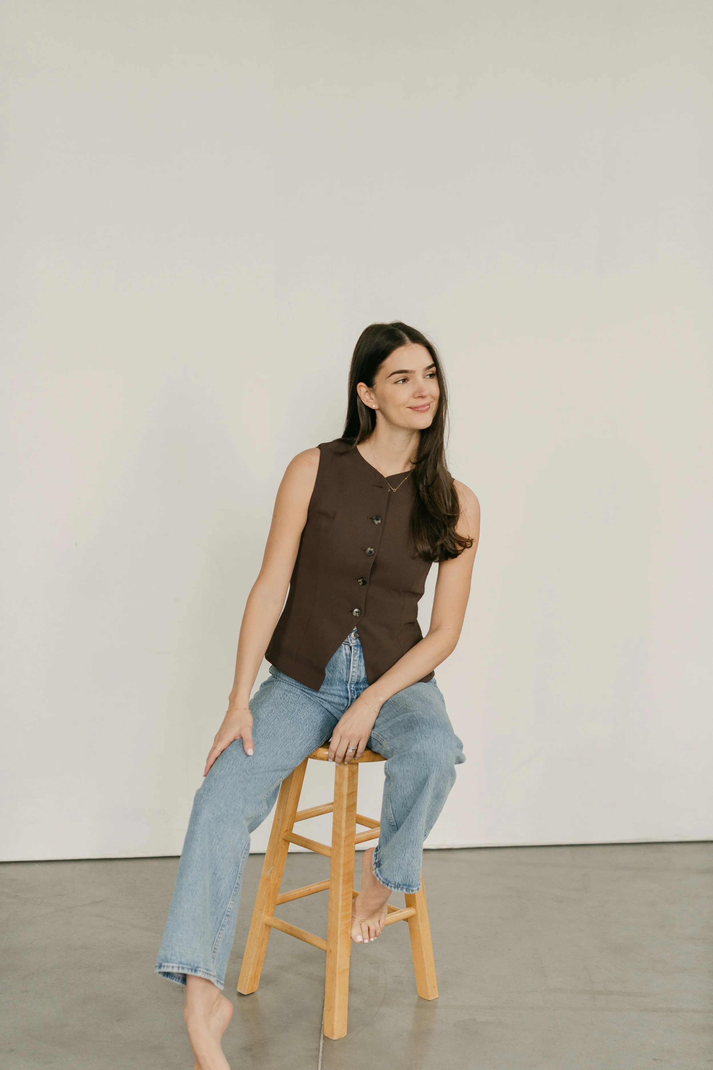 Woman seated in a simple, minimalist space, representing self-reflection and personal growth