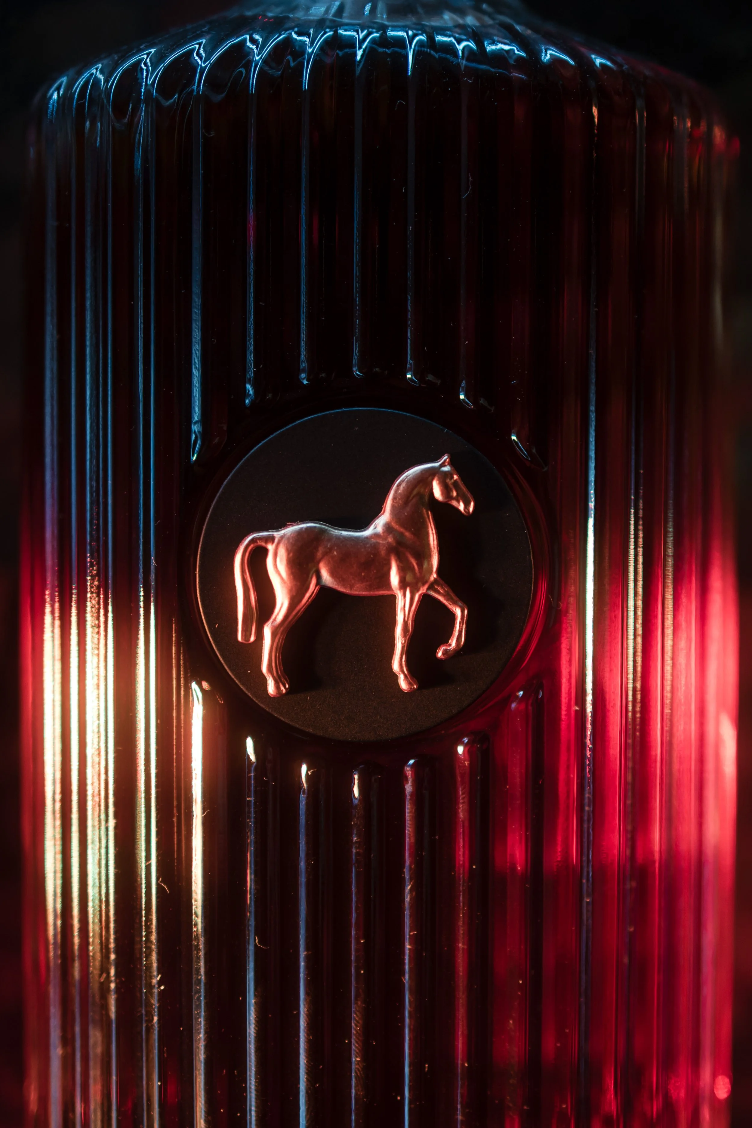 Un objet en forme de cheval en verre avec un éclairage rouge et bleu