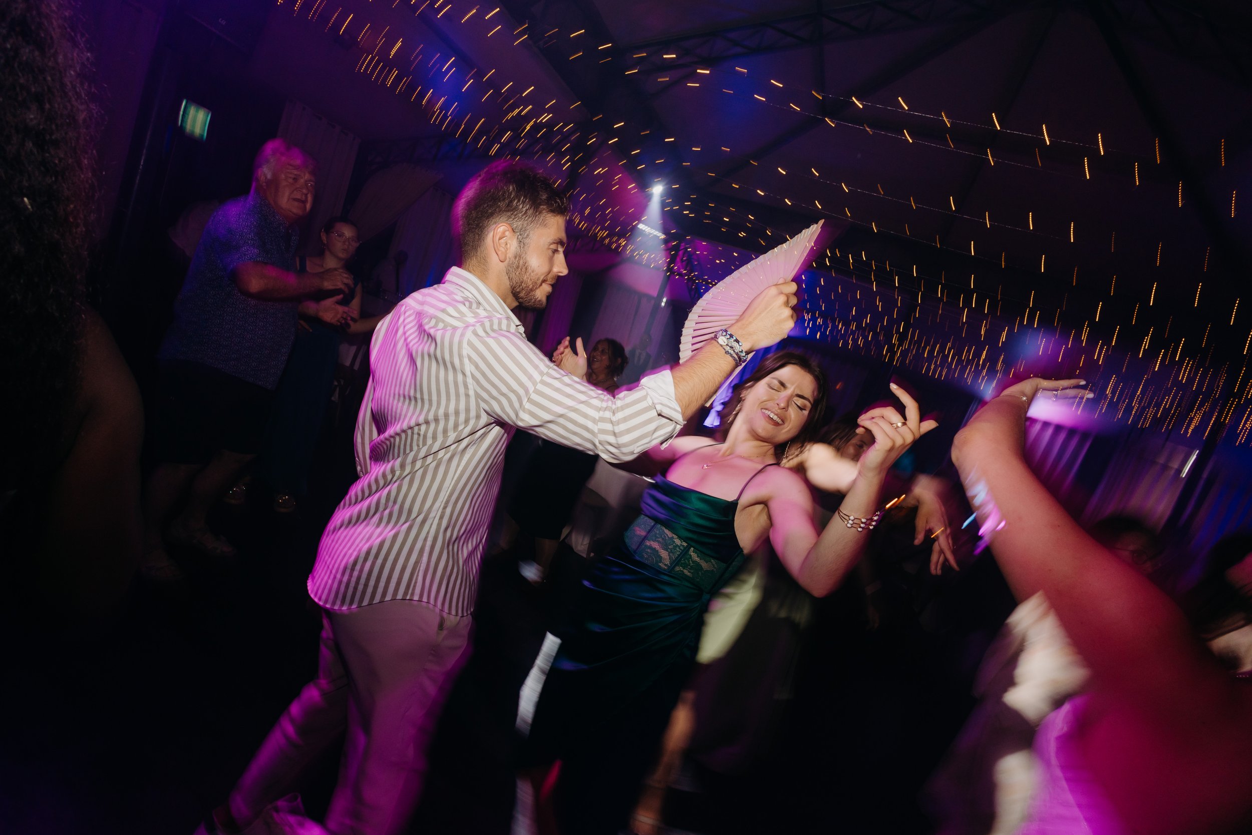 Photo d'ambiance sur le dancefloor d'un mariage. Photo de soirée moderne au flash. 