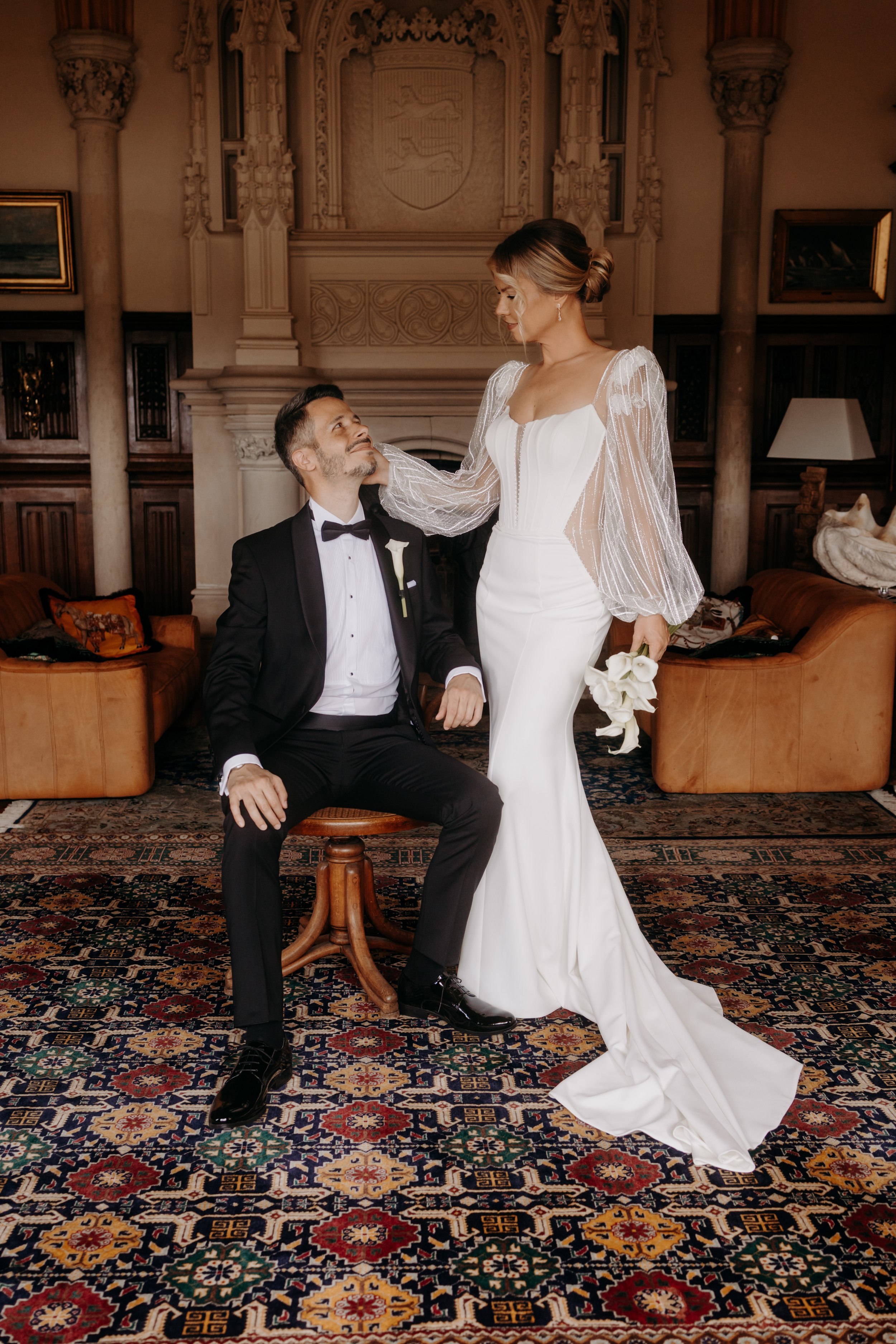 Un couple en robe de mariage pose dans la suite de leur lieu de réception de Mariage. Photo de mariage moderne et éditorial. 