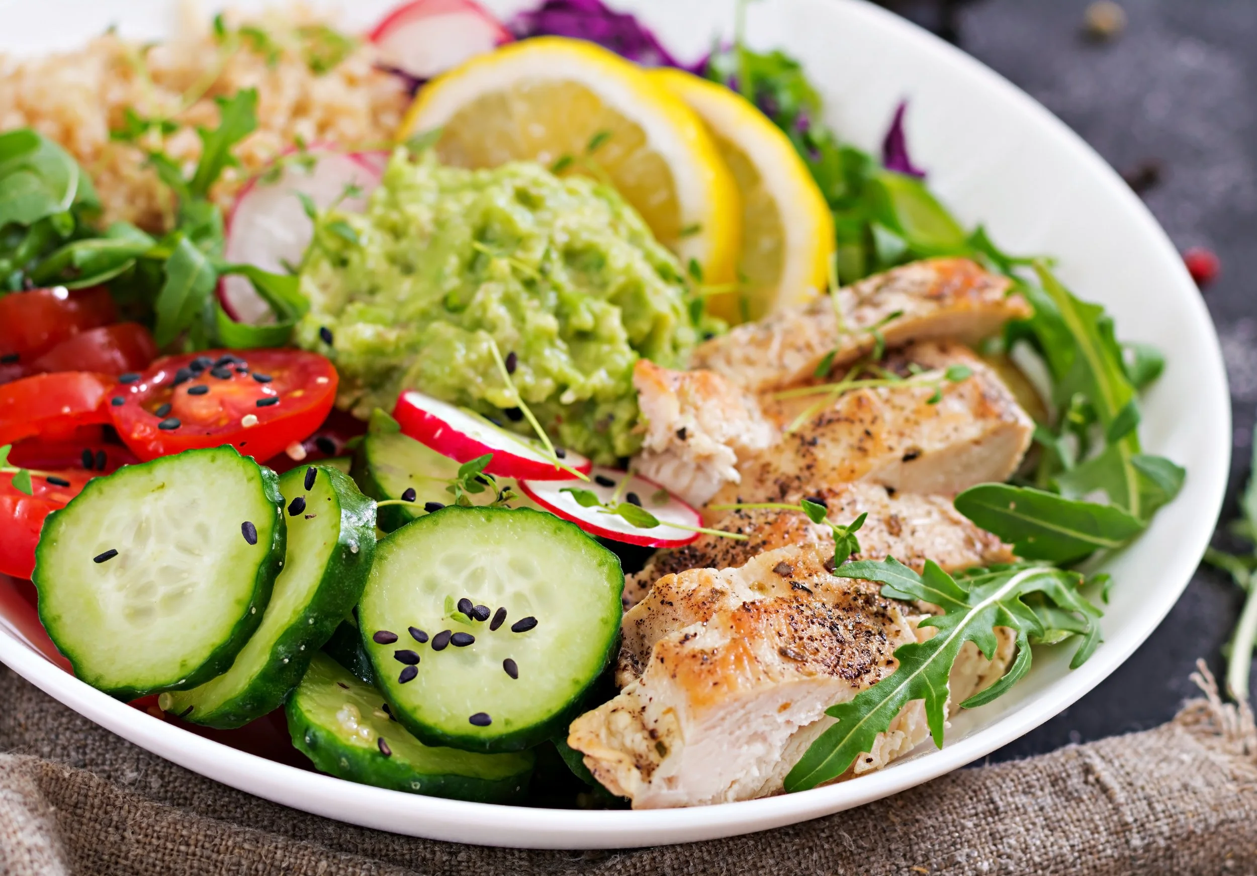 healthy-dinner-buddha-bowl-lunch-with-grilled-chicken-quinoa-tomato-guacamole-red-cabbage-cucumber-arugula.jpg