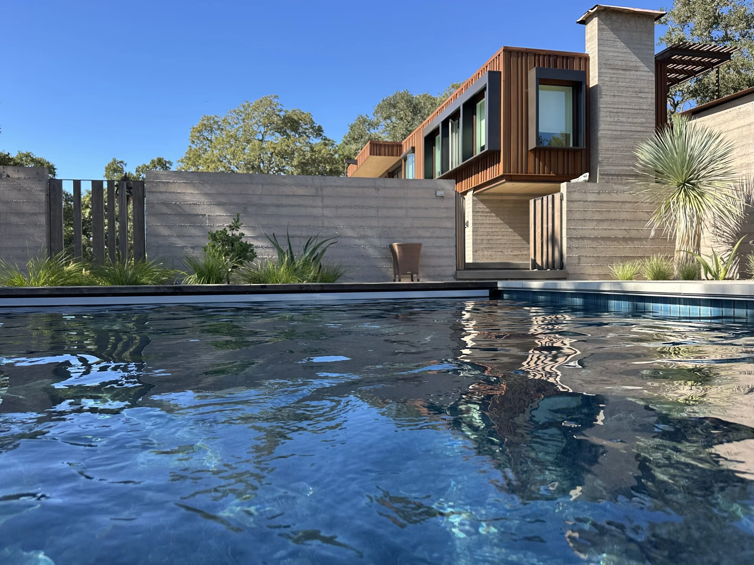 Corten siding, board form concrete, fire shutters for wildfire resistance.