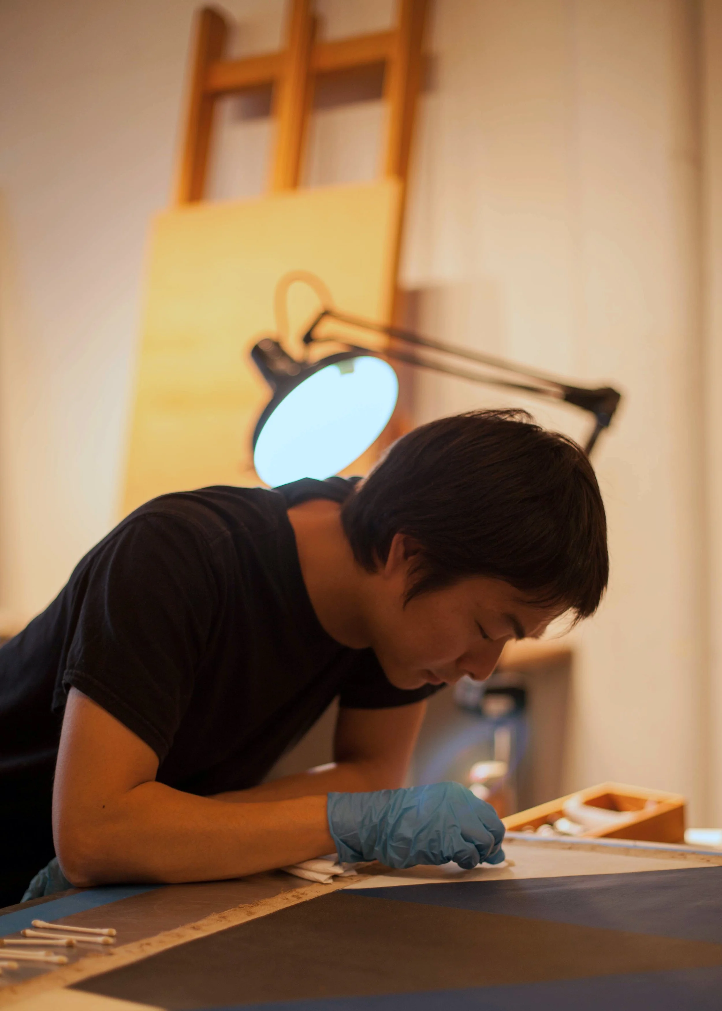 Art restore cleaning a surface of a painting.