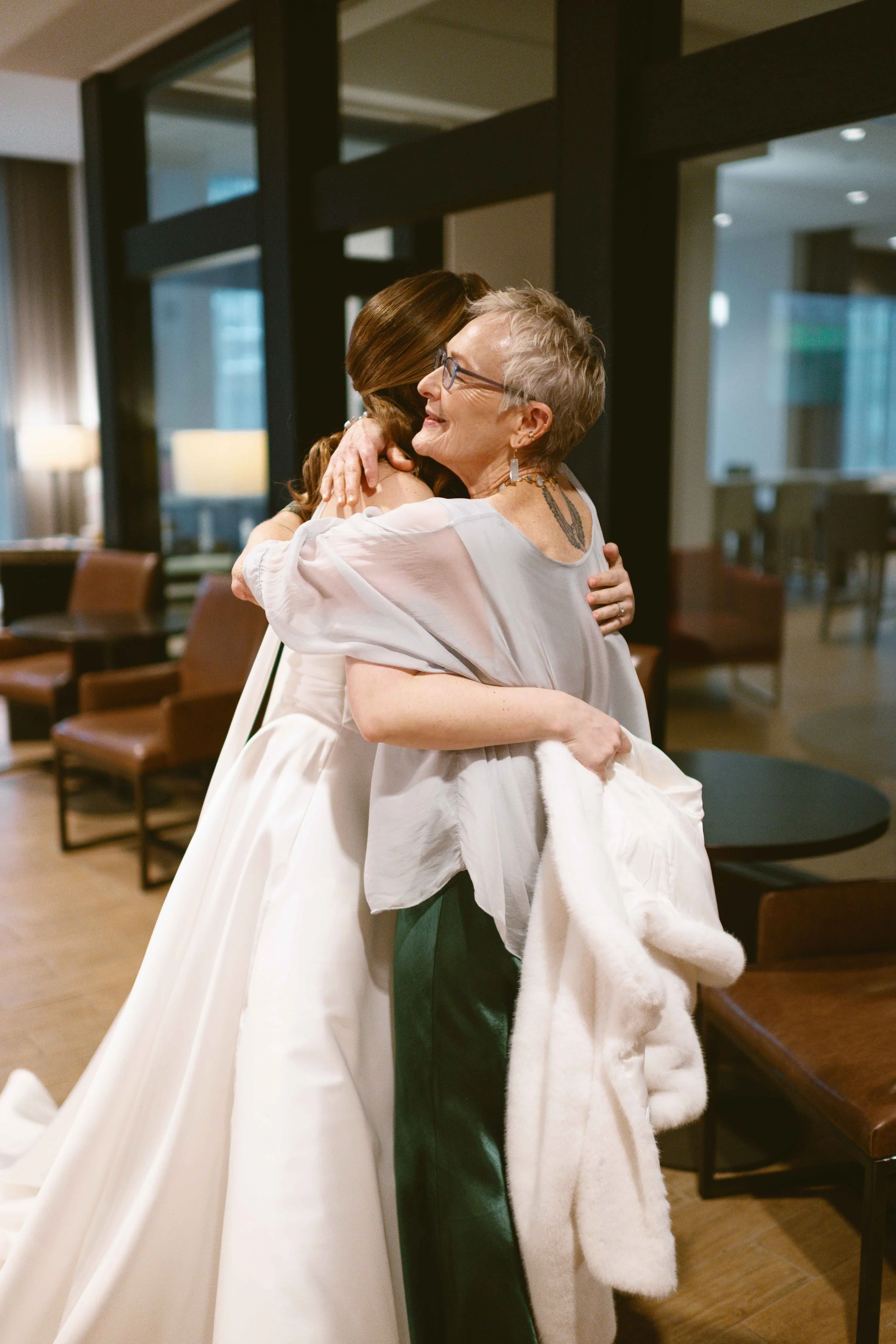 Bride hugging mother-in-law in hotel lobby of Chicago hotel