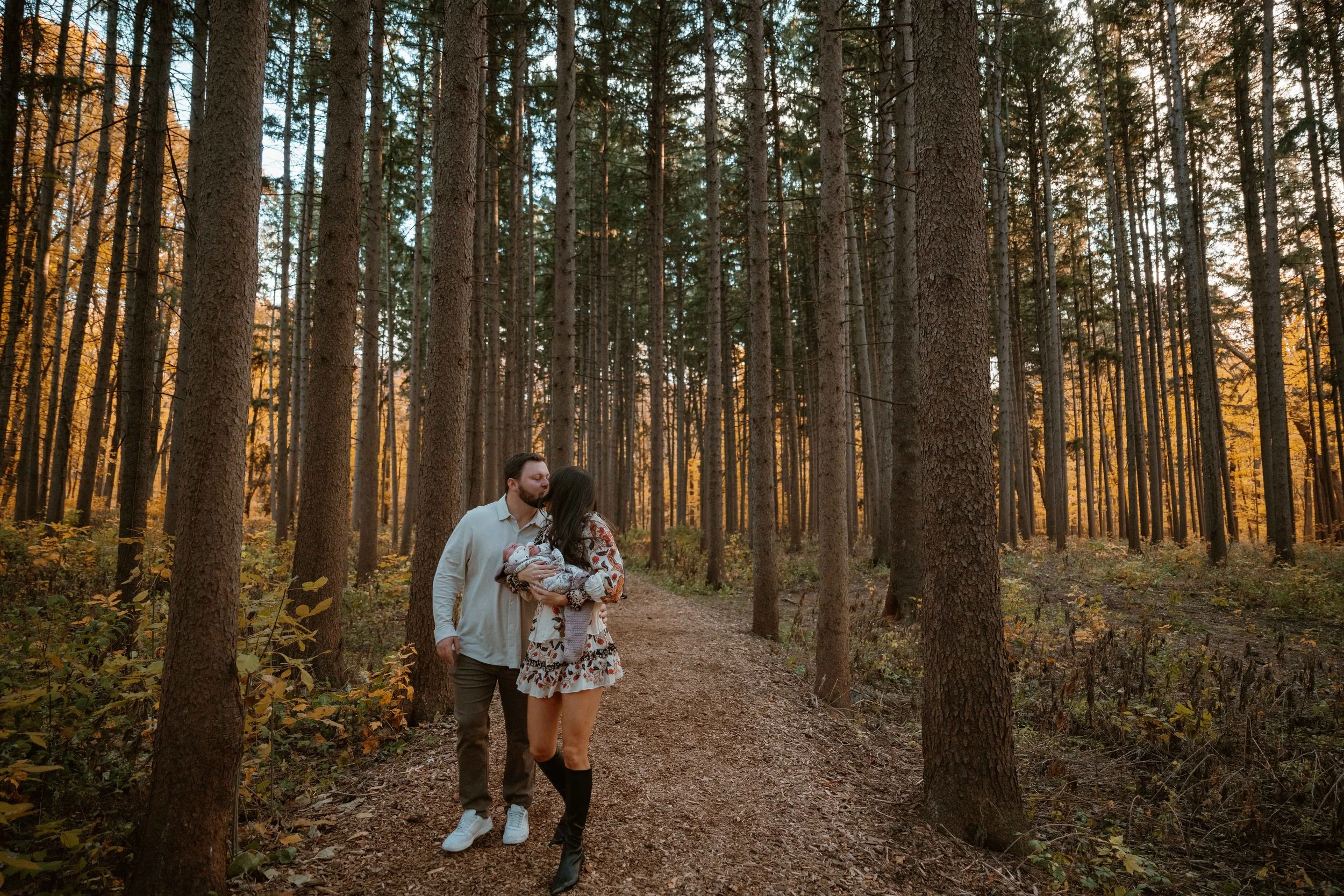 dad kissing mom on during walk at Morton Arboretum Lisle IL 