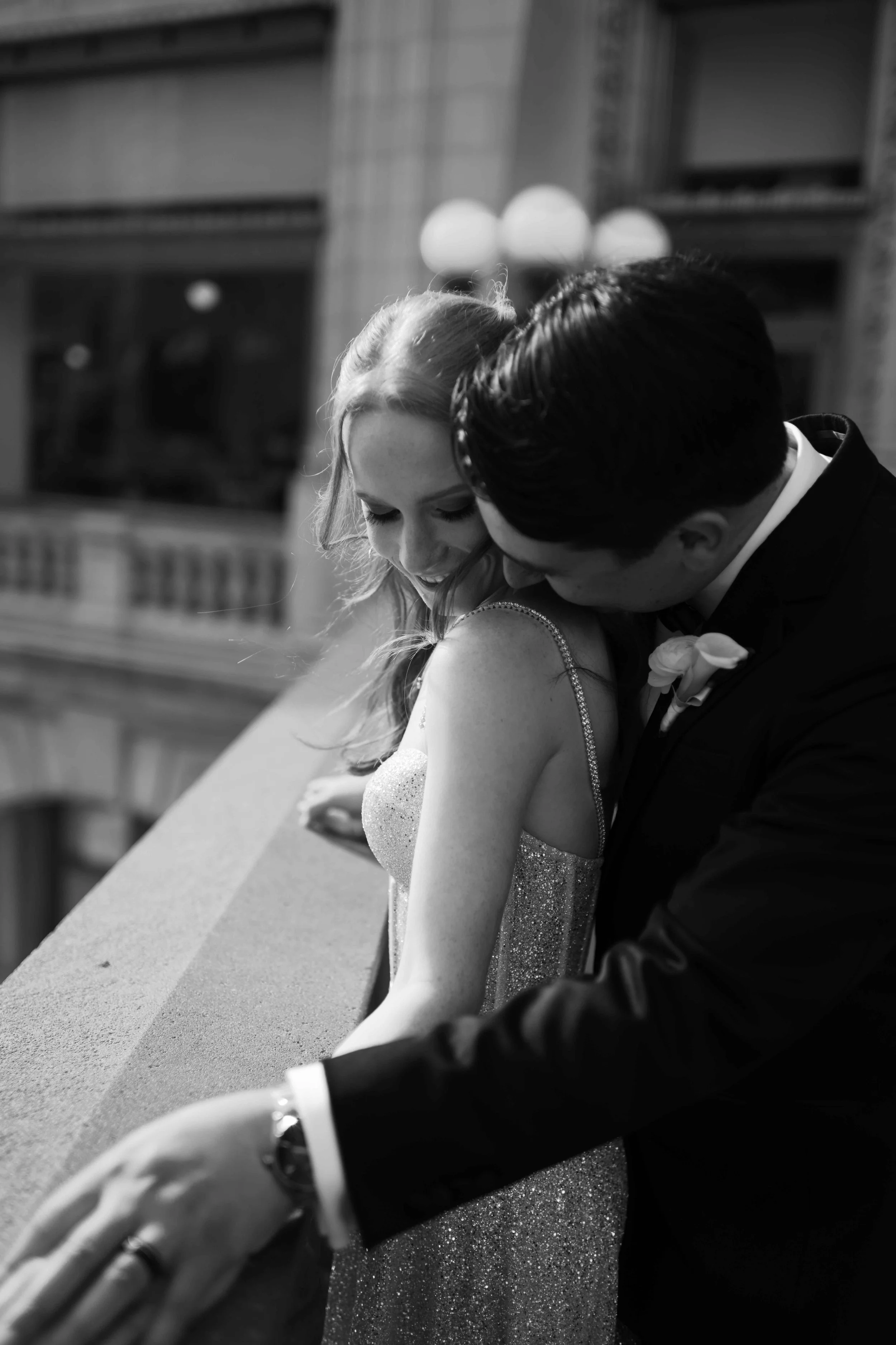 Black and white photograph of a groom kissing his bride's neck at their downtown Chicago IL wedding