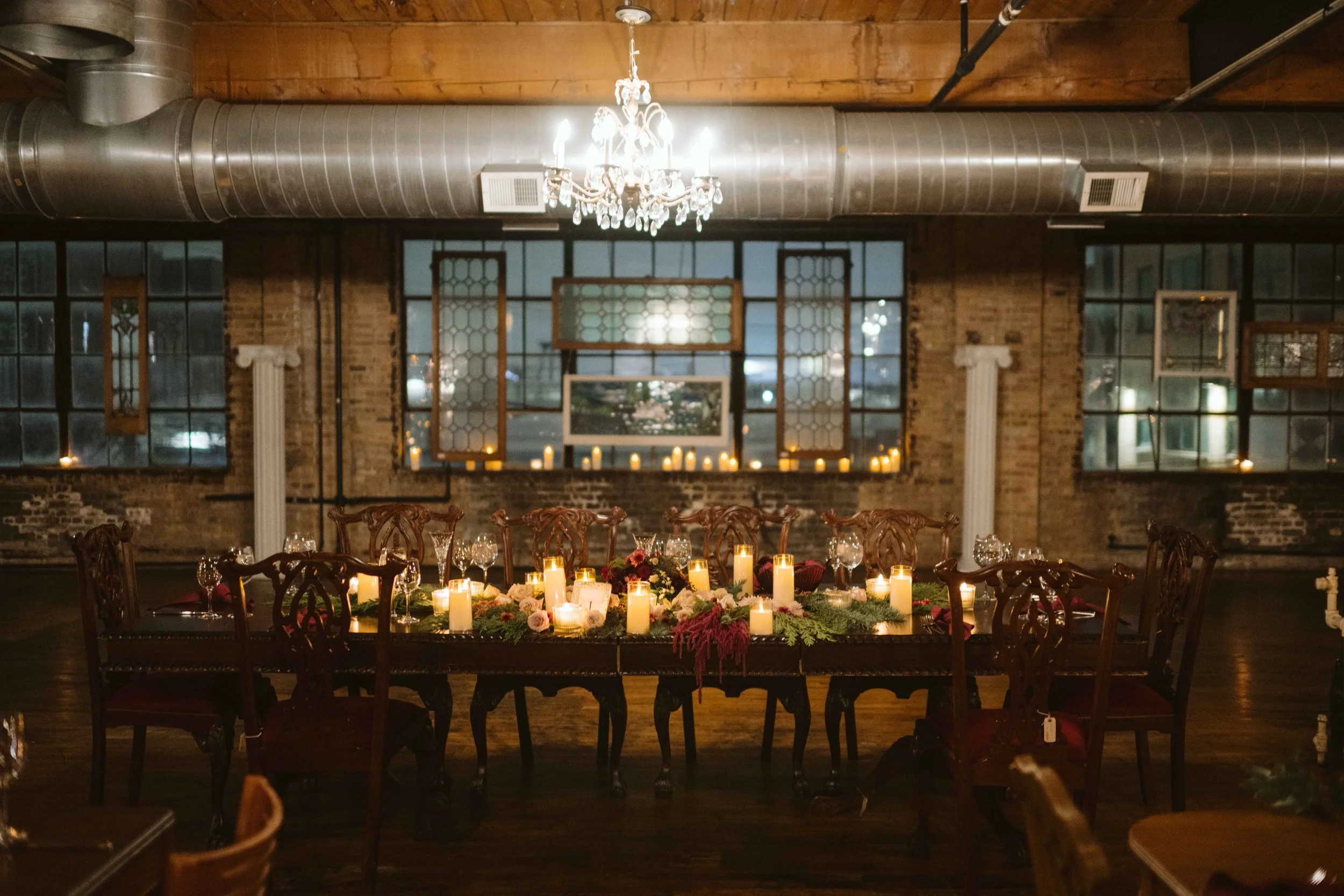 salvage one chicago wedding reception head table with greenery and candles