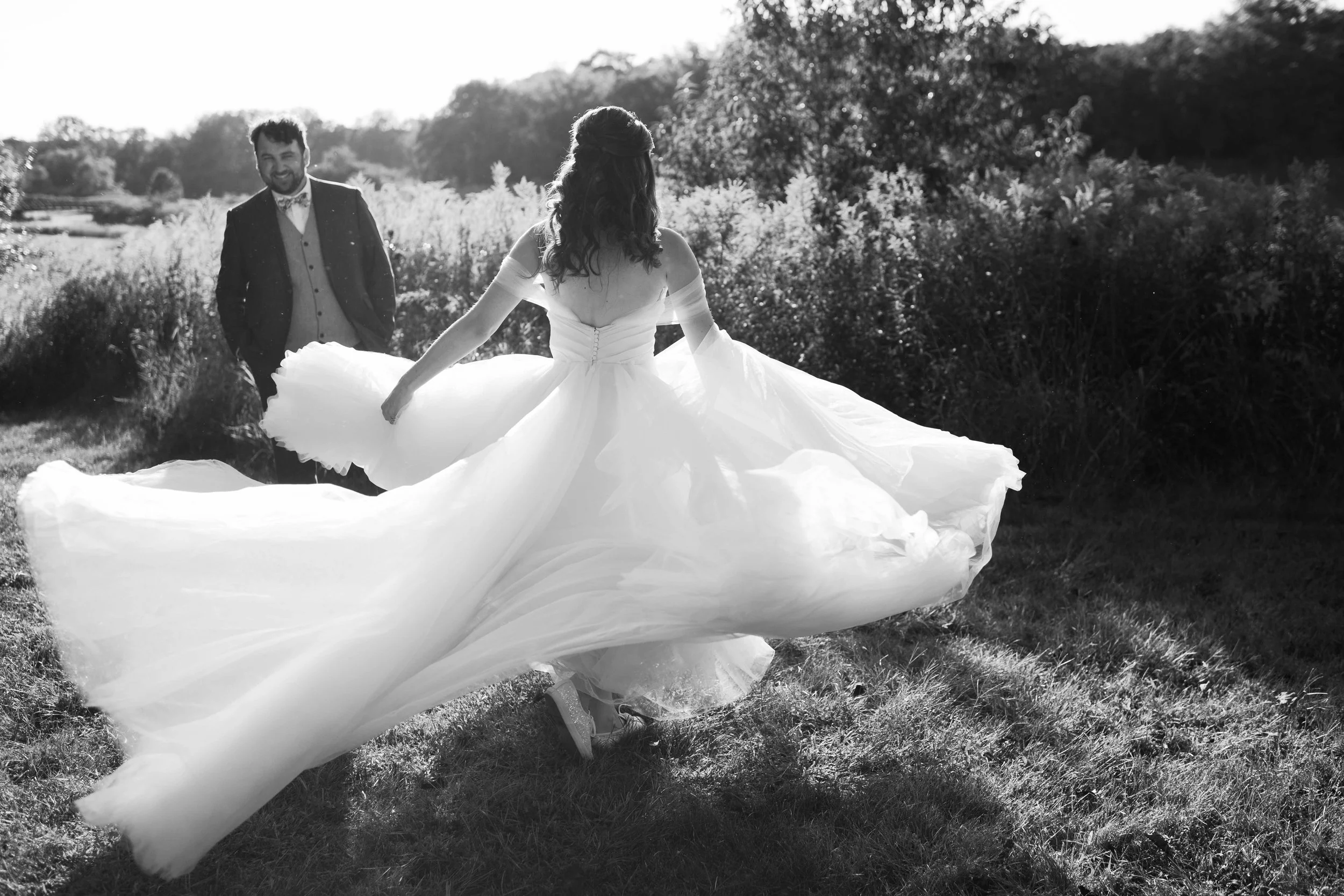 Groom admiring his bride as she spins in her wedding dress at Independence Grove Forest Preserve