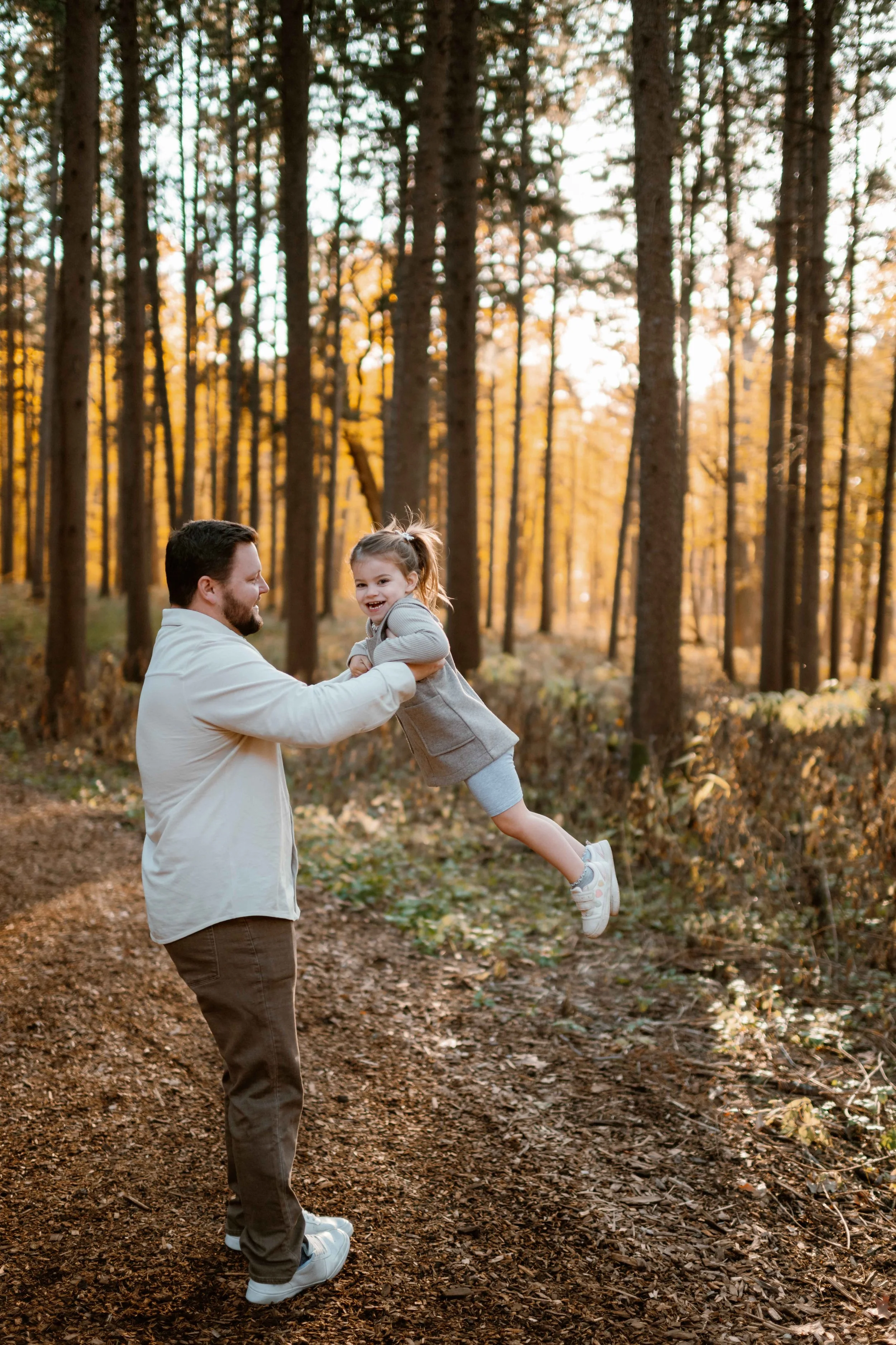 dad swinging daughter around at Morton Arboretum Lisle IL 
