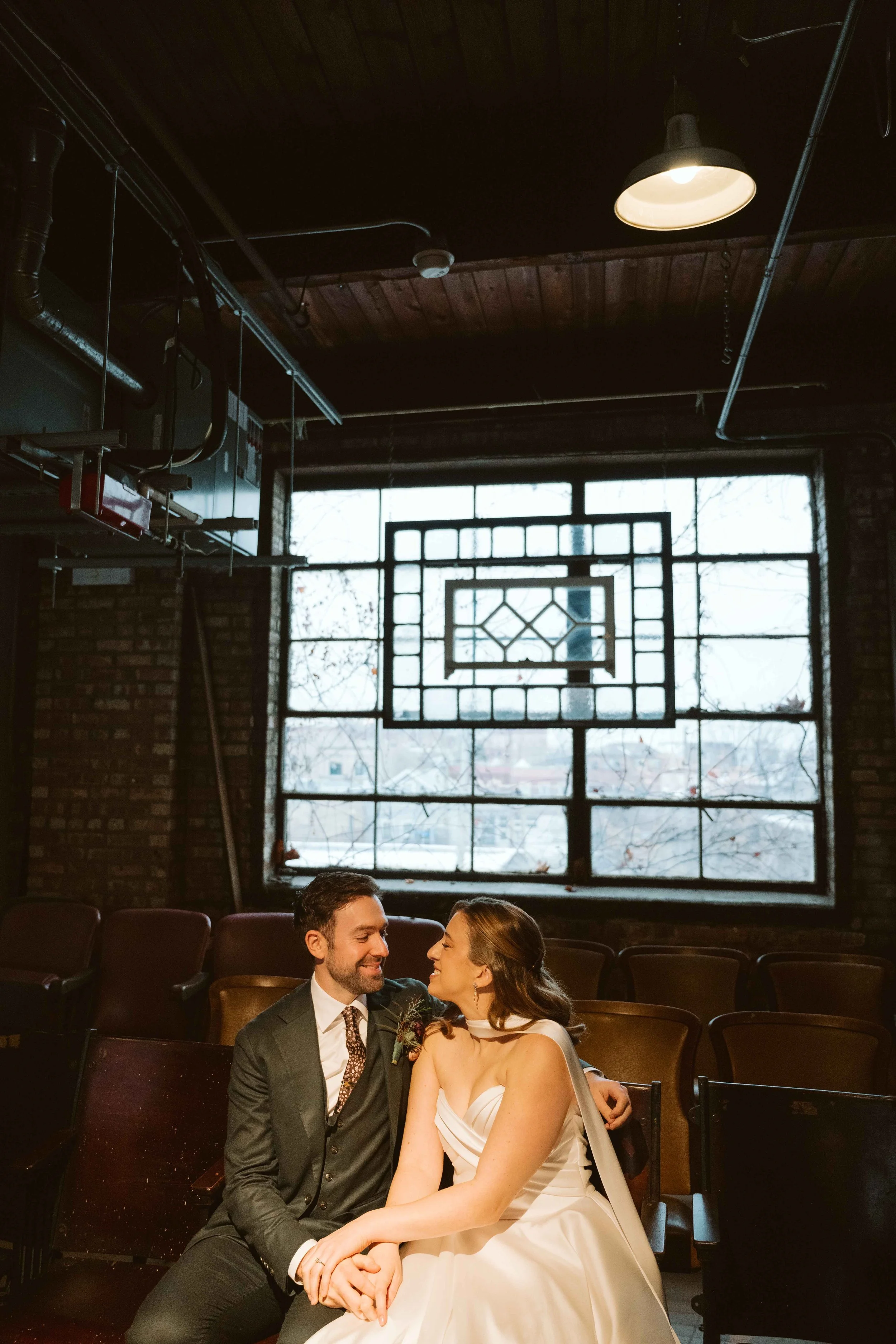 bride and groom sitting in antique theatre seats at Salvage One in Chicago
