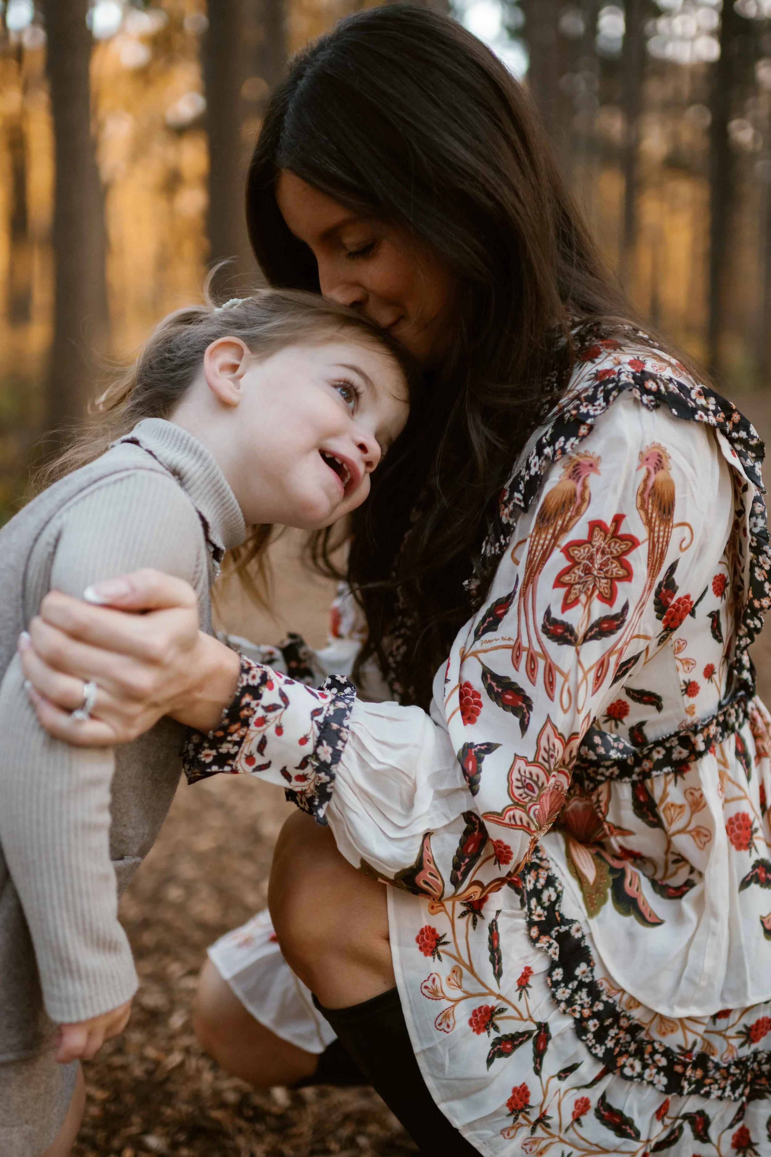 mom kissing daughter head during family photos at Morton Arboretum Lisle IL 