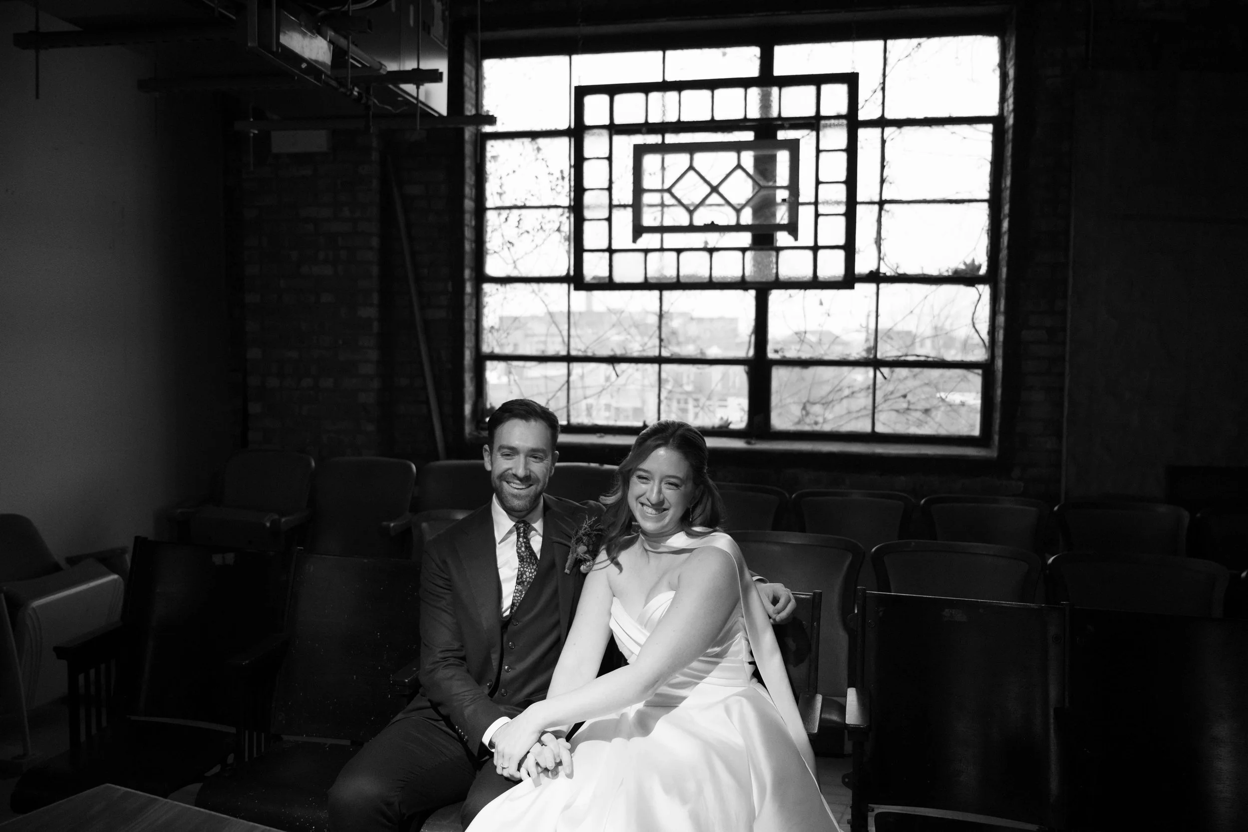 black and white photo of bride and groom on theatre seats at Salvage One in Chicago