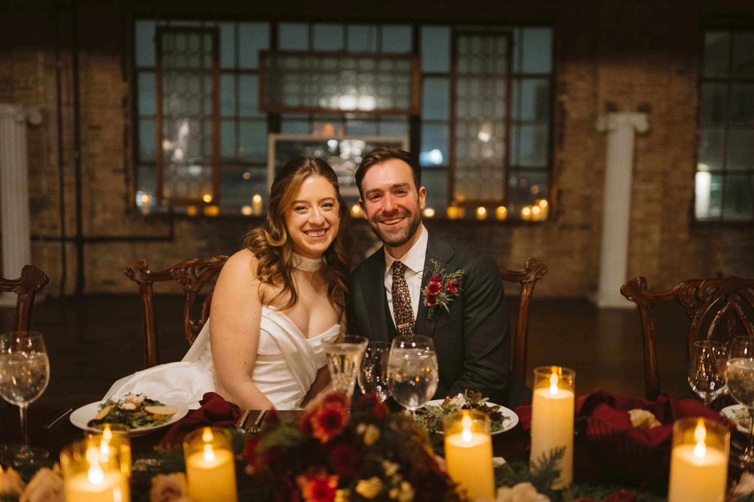 salvage one chicago bride and groom smiling during reception at head table