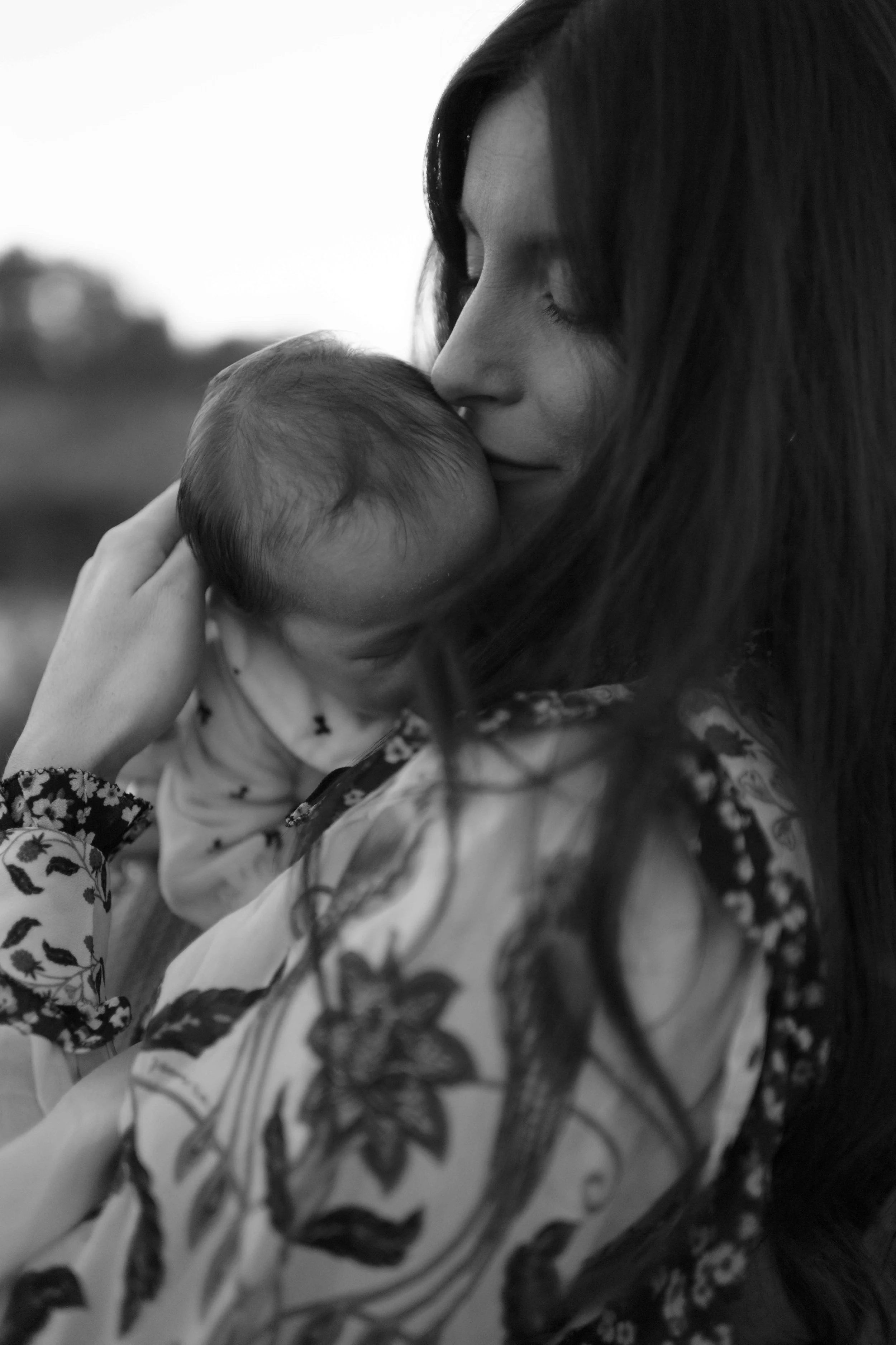 black and white new baby and mama snuggle during family photos 