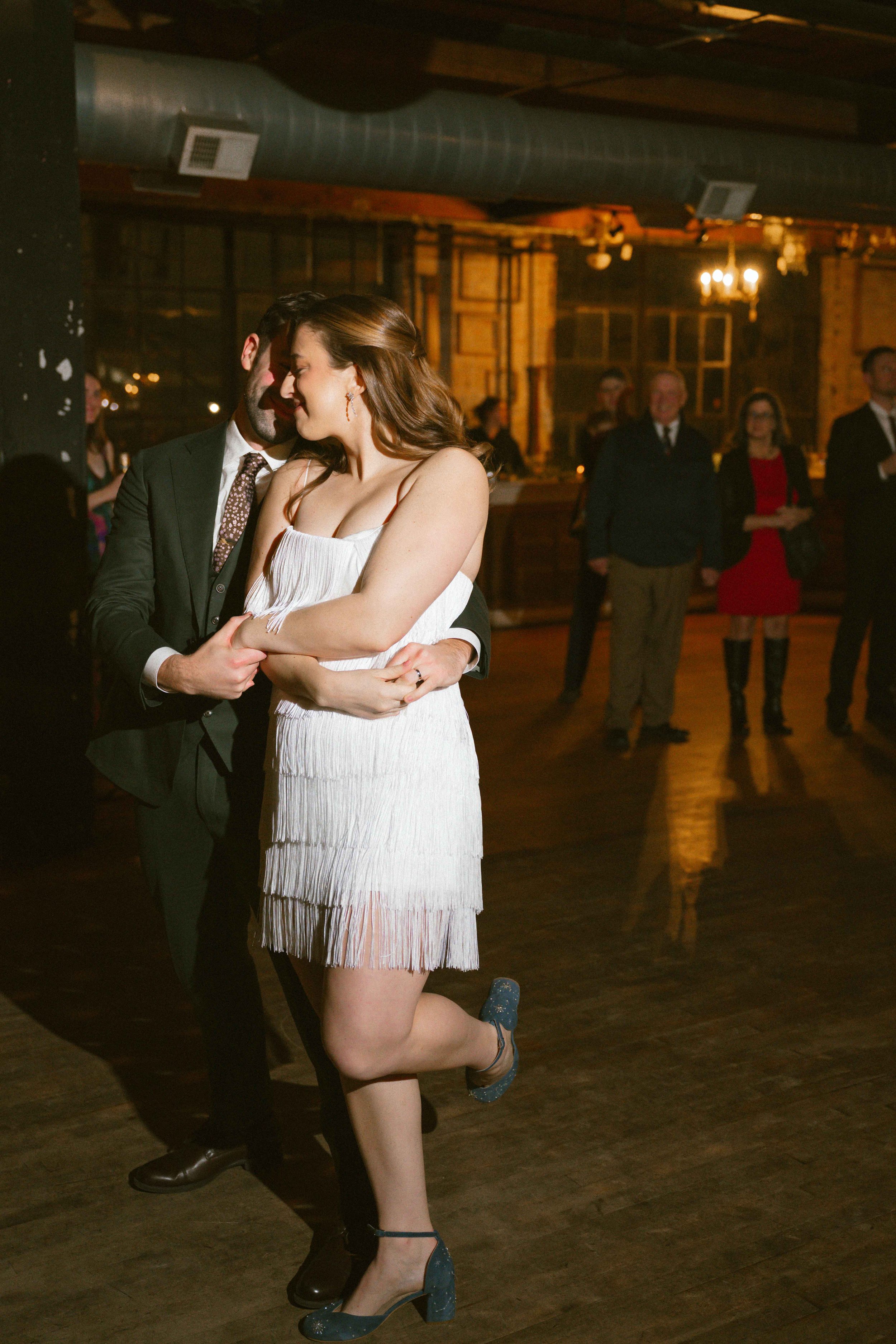 salvage one chicago wedding reception first dance of bride and groom with a fringe dress change