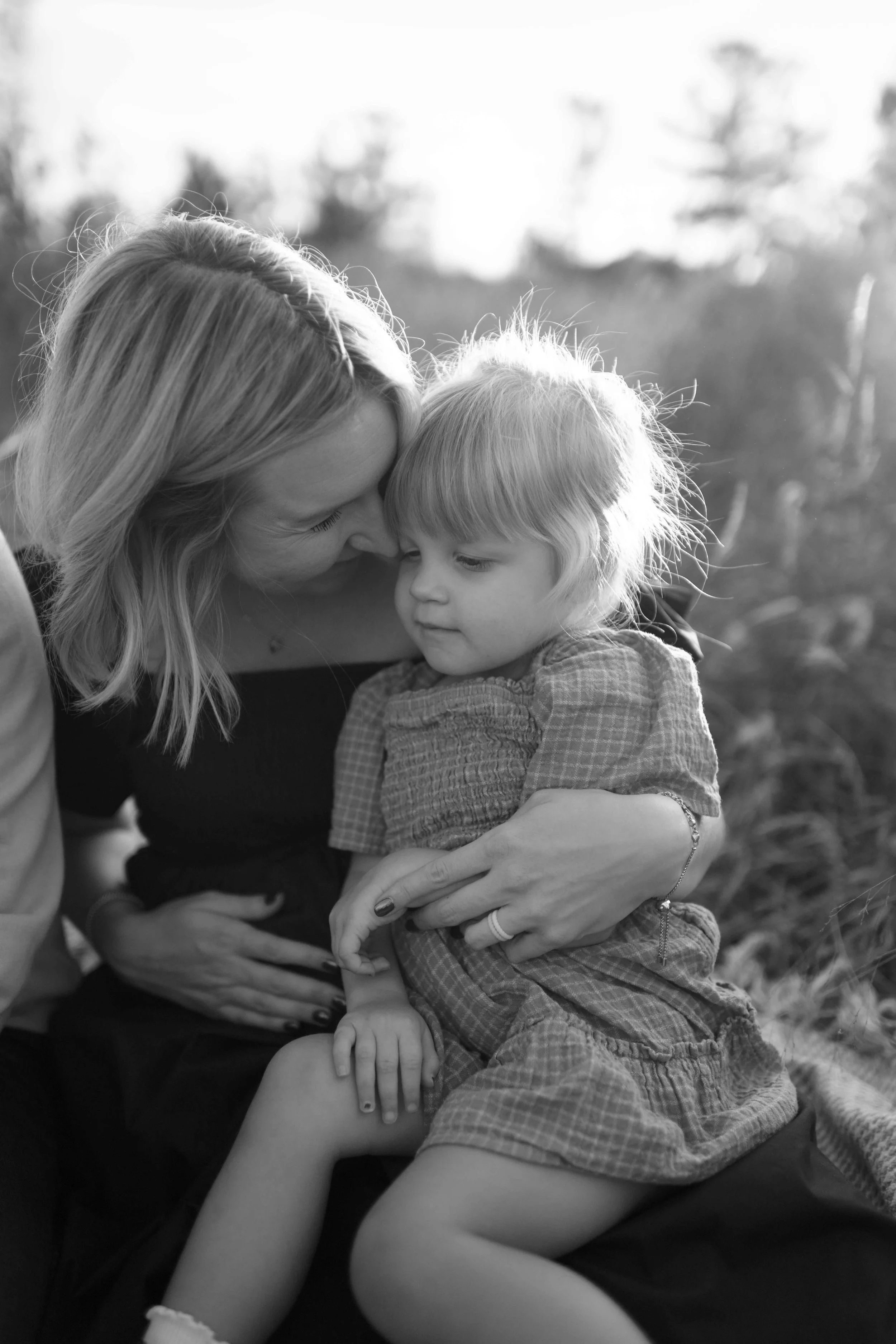 mother nuzzling daughter on her lap at Blackwell Forest Preserve in Wheaton 
