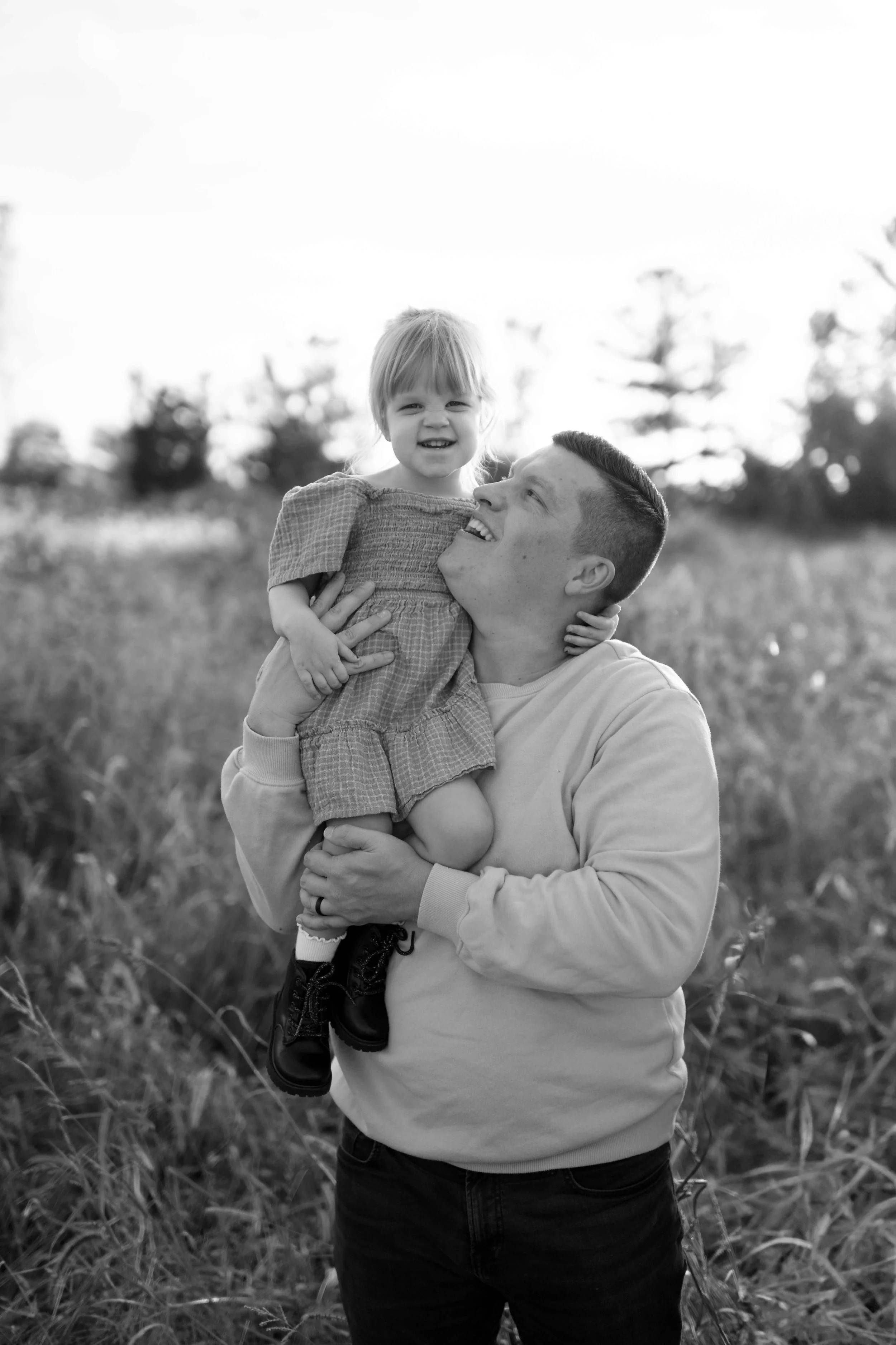 black and white photo of dad looking up at daughter on his shoulder at Blackwell Forest Preserve in Wheaton 