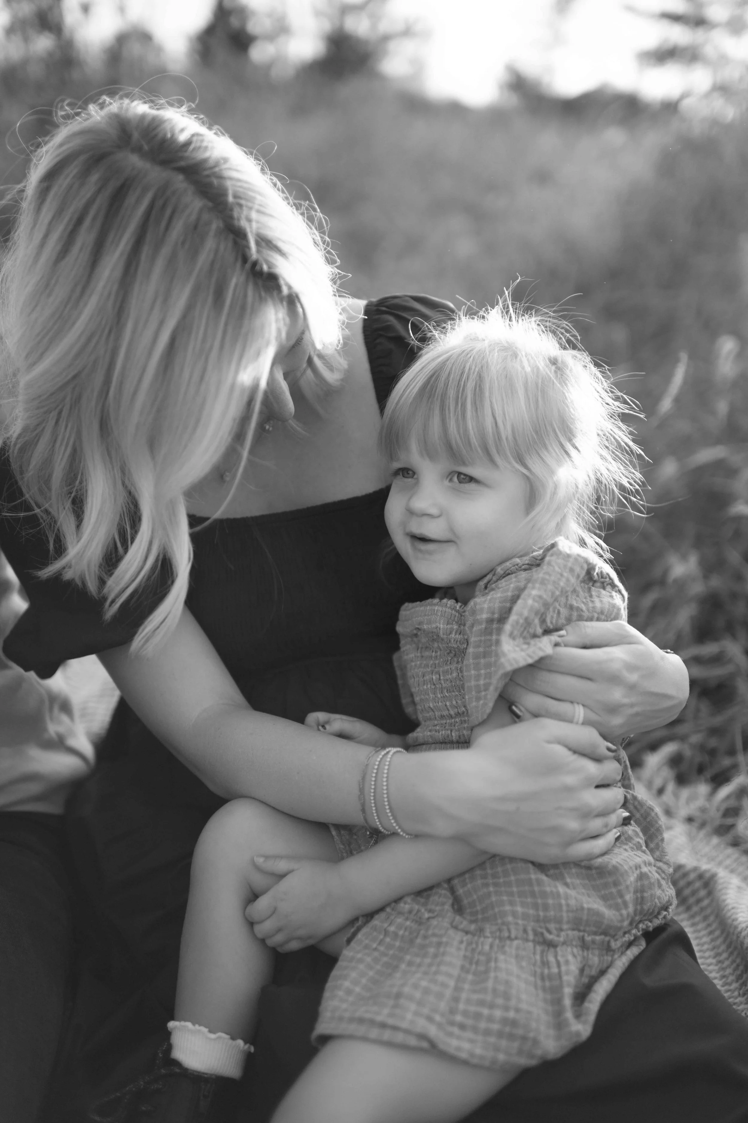 black and white photo of daughter on mom's pregnant belly lap at Blackwell Forest Preserve Wheaton 