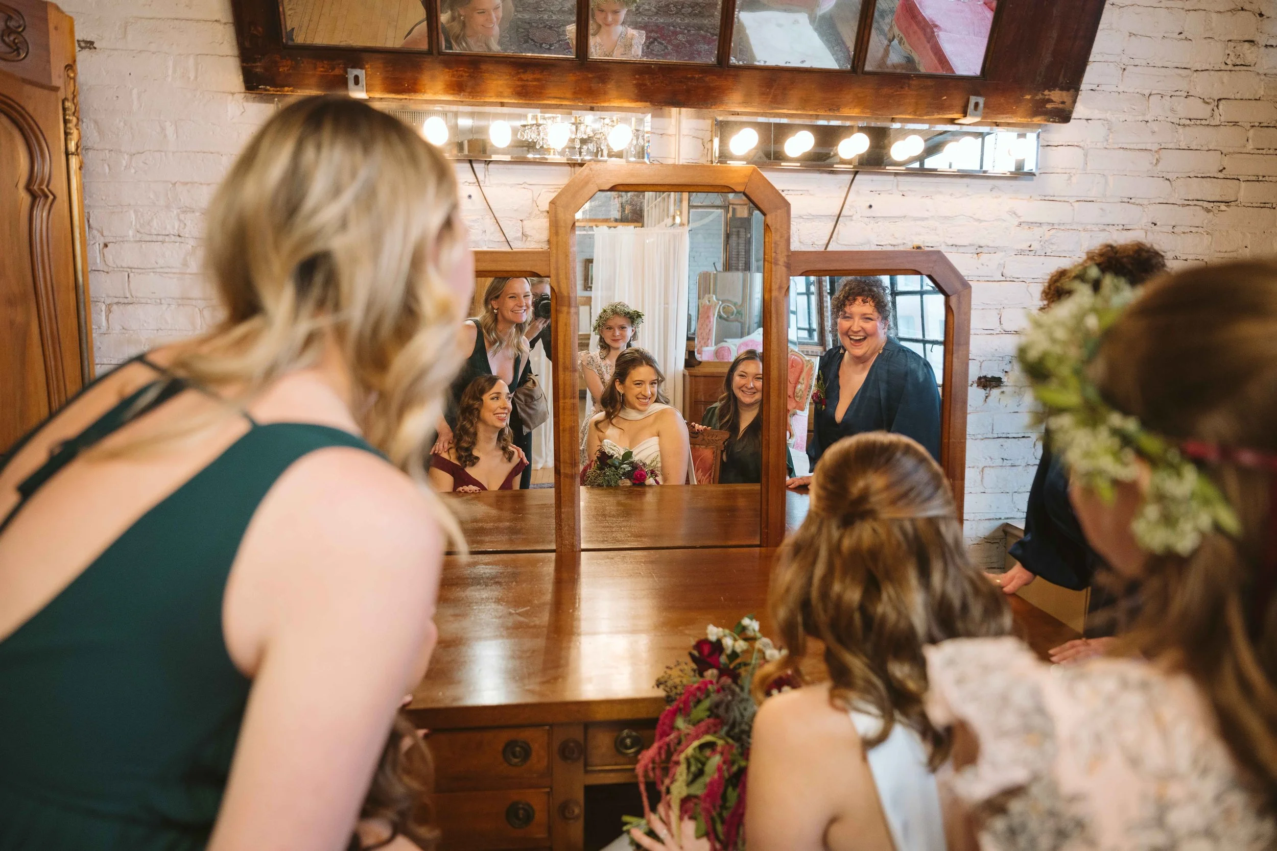 Bride and bridesmaids looking into mirror together in bridal suite at Salvage One in Chicago
