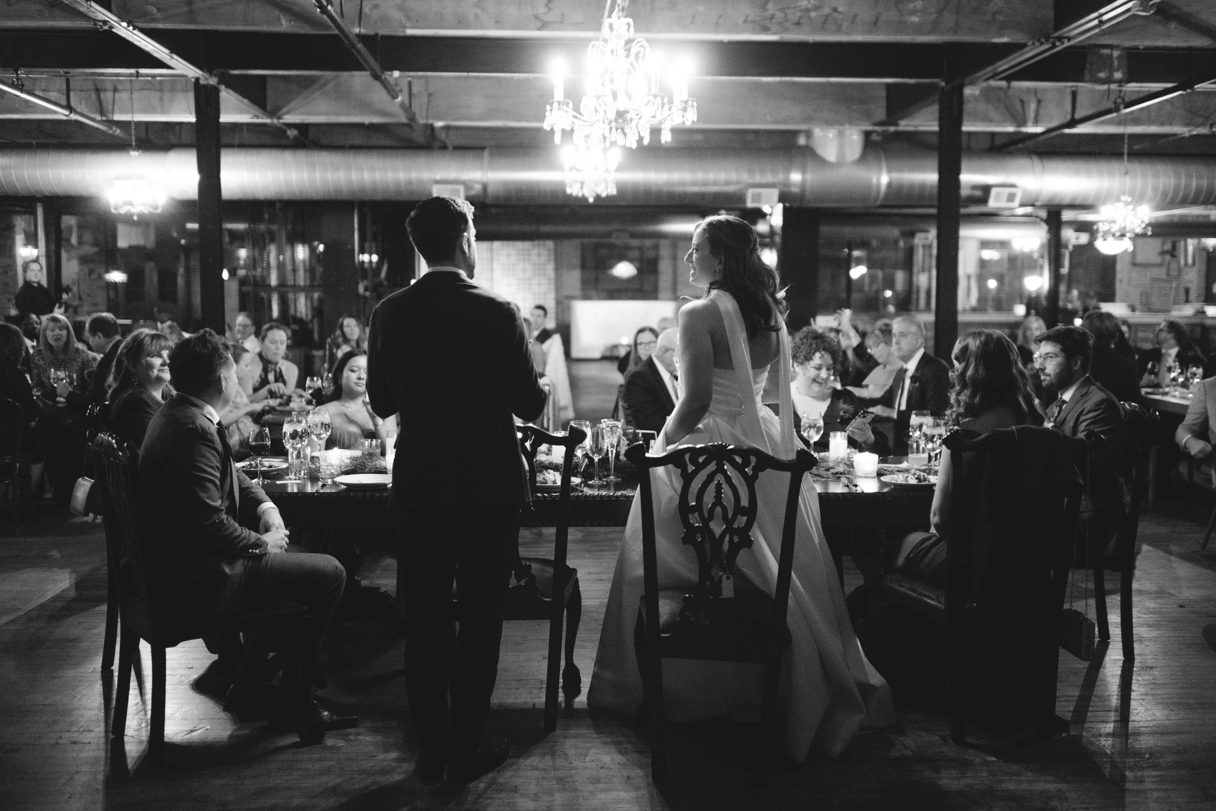 salvage one chicago black and white shot of back of bride and groom at head table at reception