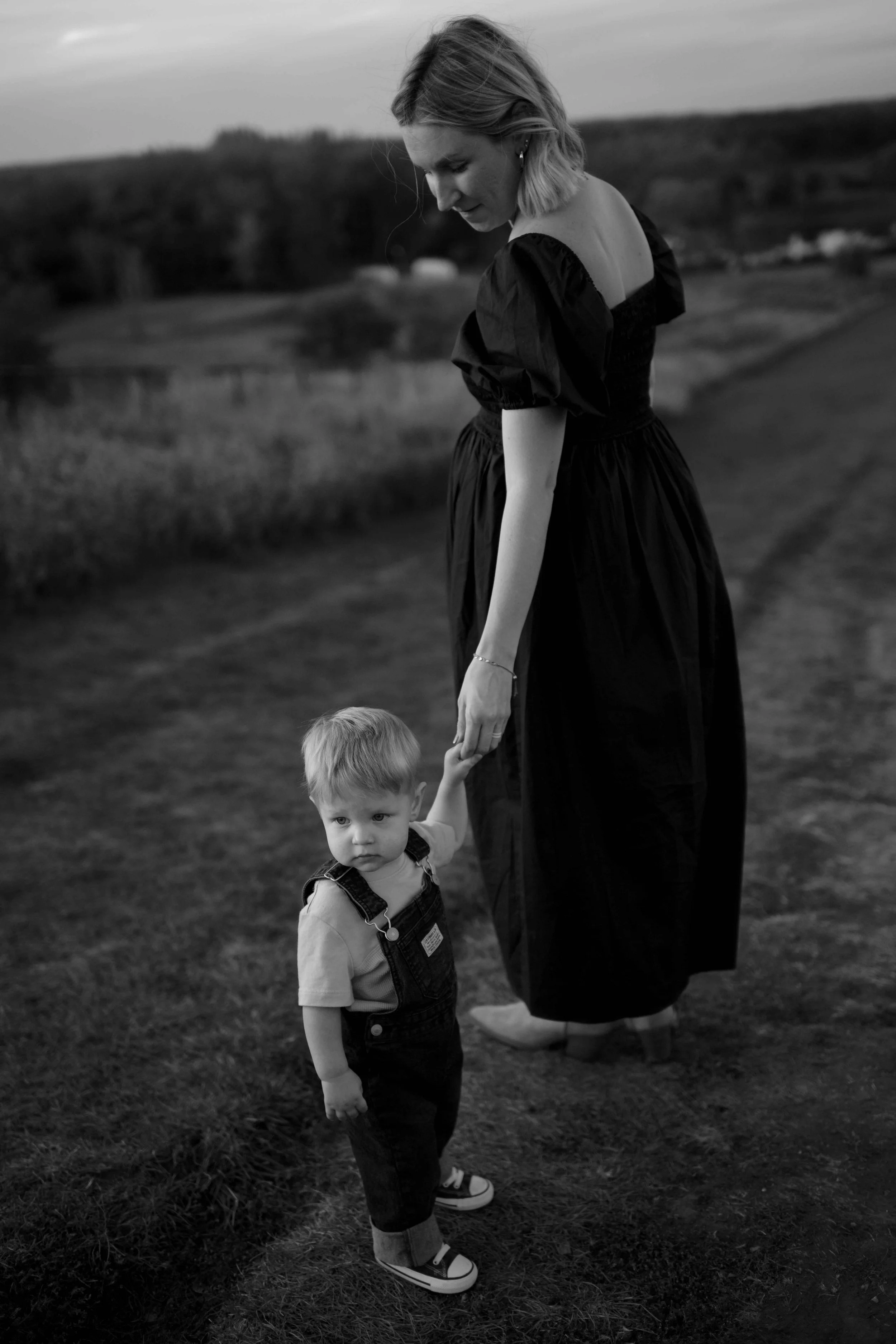 black and white photo of mom holding son's hand at blackwell forest preserve in Wheaton