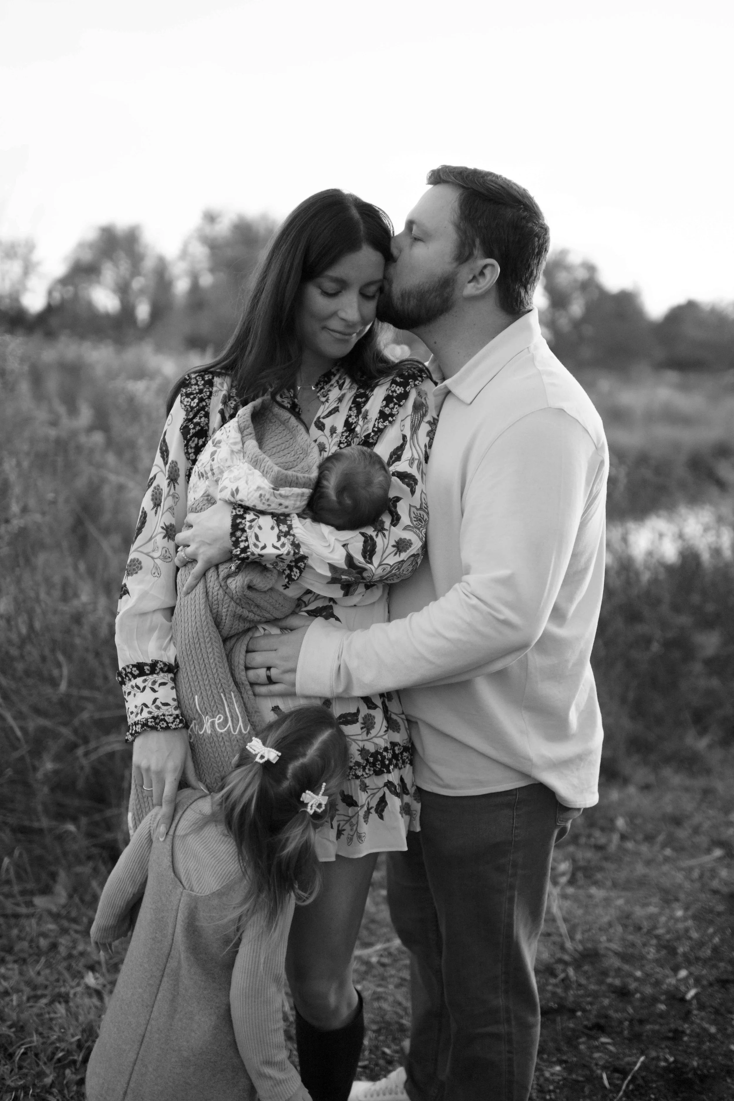 black and white family photo dad kissing mom on side of the head at the Morton Arboretum Lisle IL 
