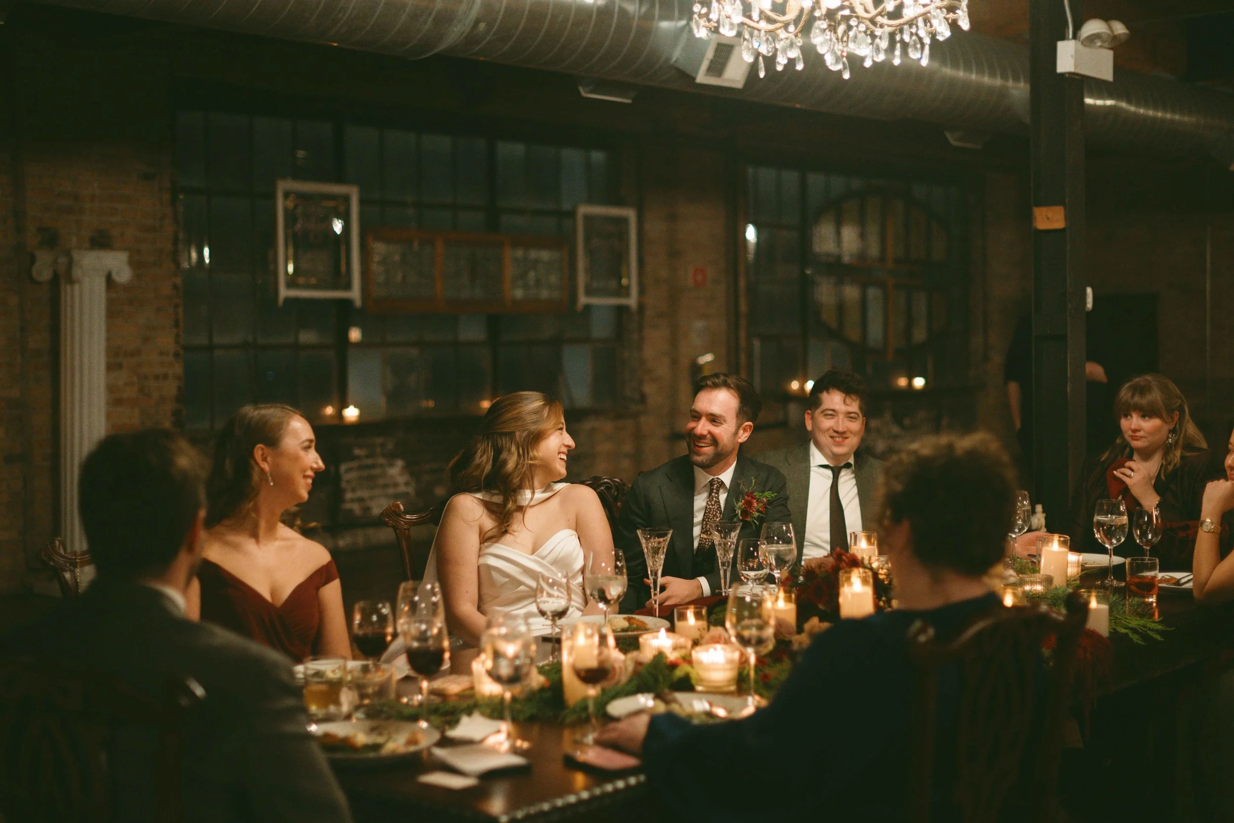 salvage one chicago wedding reception bride and groom smiling at each other at head table